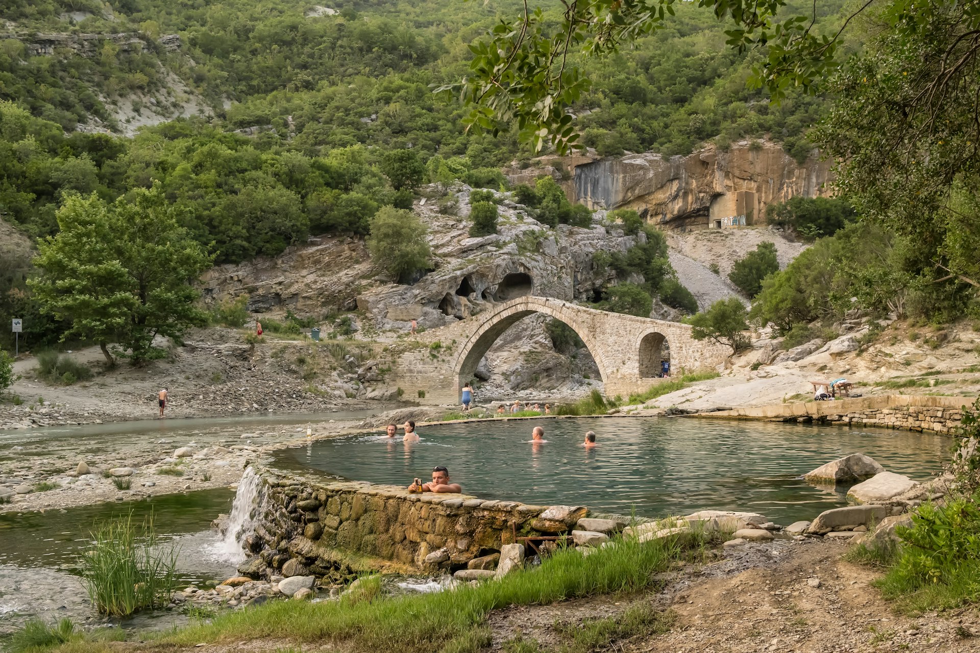 Tourists soak in the Bënjë Thermal Baths alongside the Vjosa River in Permet, Albania