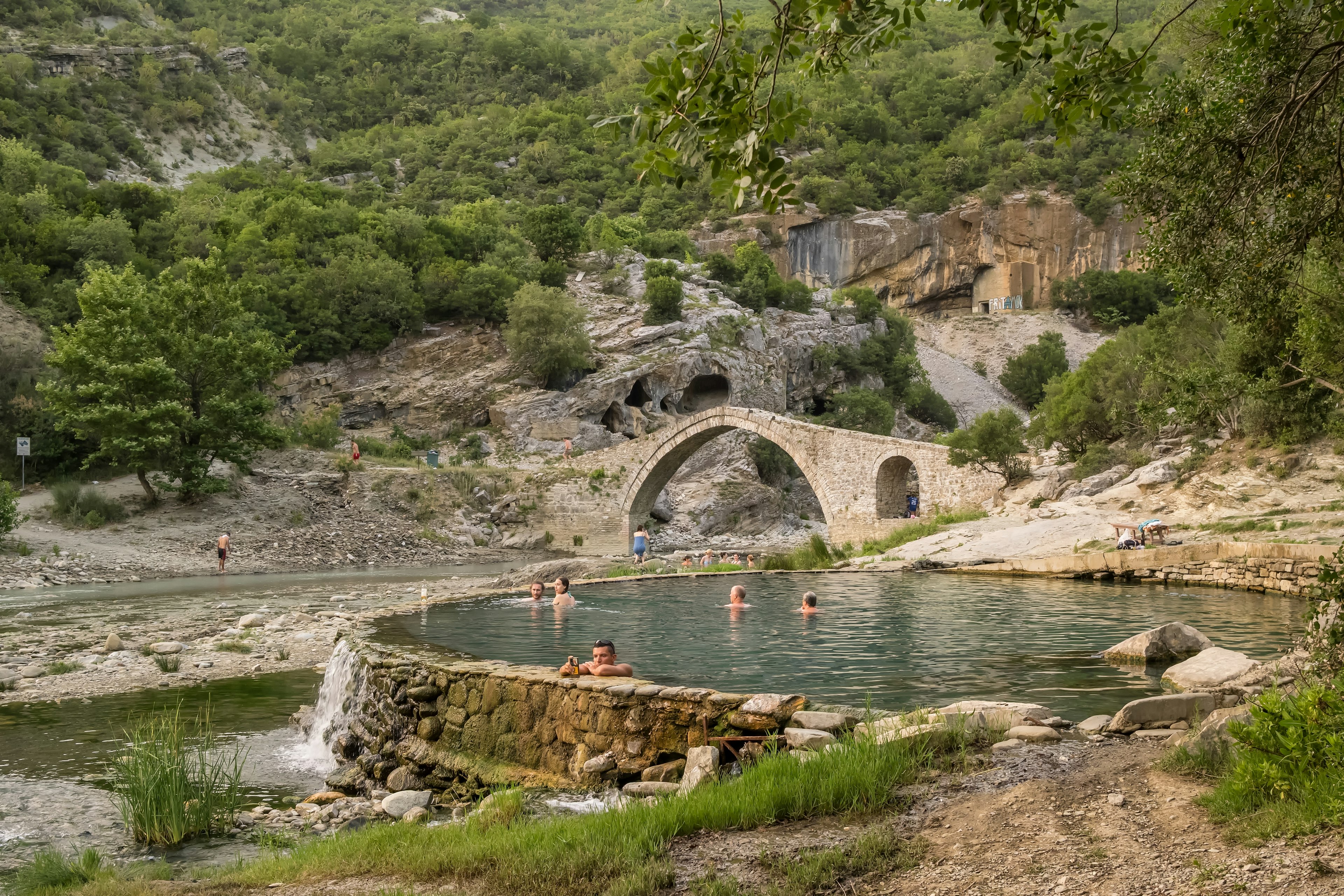 Tourists soak in the Bënjë Thermal Baths alongside the Vjosa River in Permet, Albania