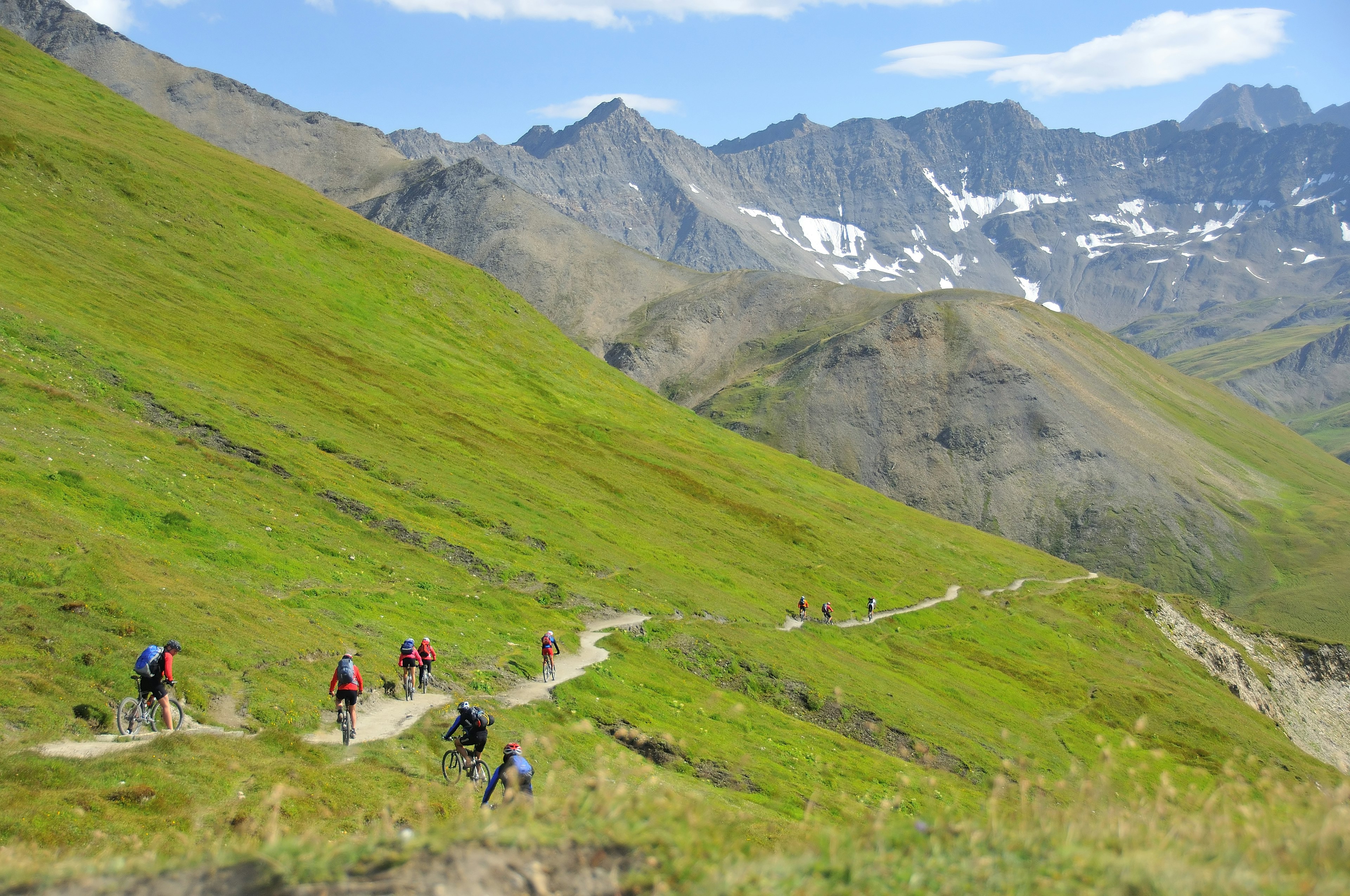 A group of mountain bikers descend down a narrow trail near Mont Blanc, Alps, Europe