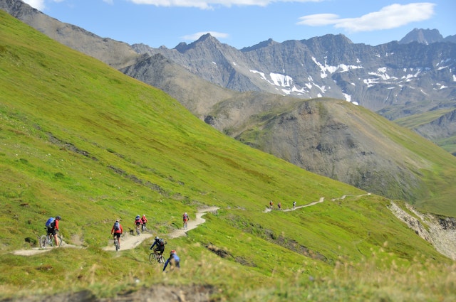 A group of mountain bikers descend down a narrow trail near Mont Blanc, Alps, Europe