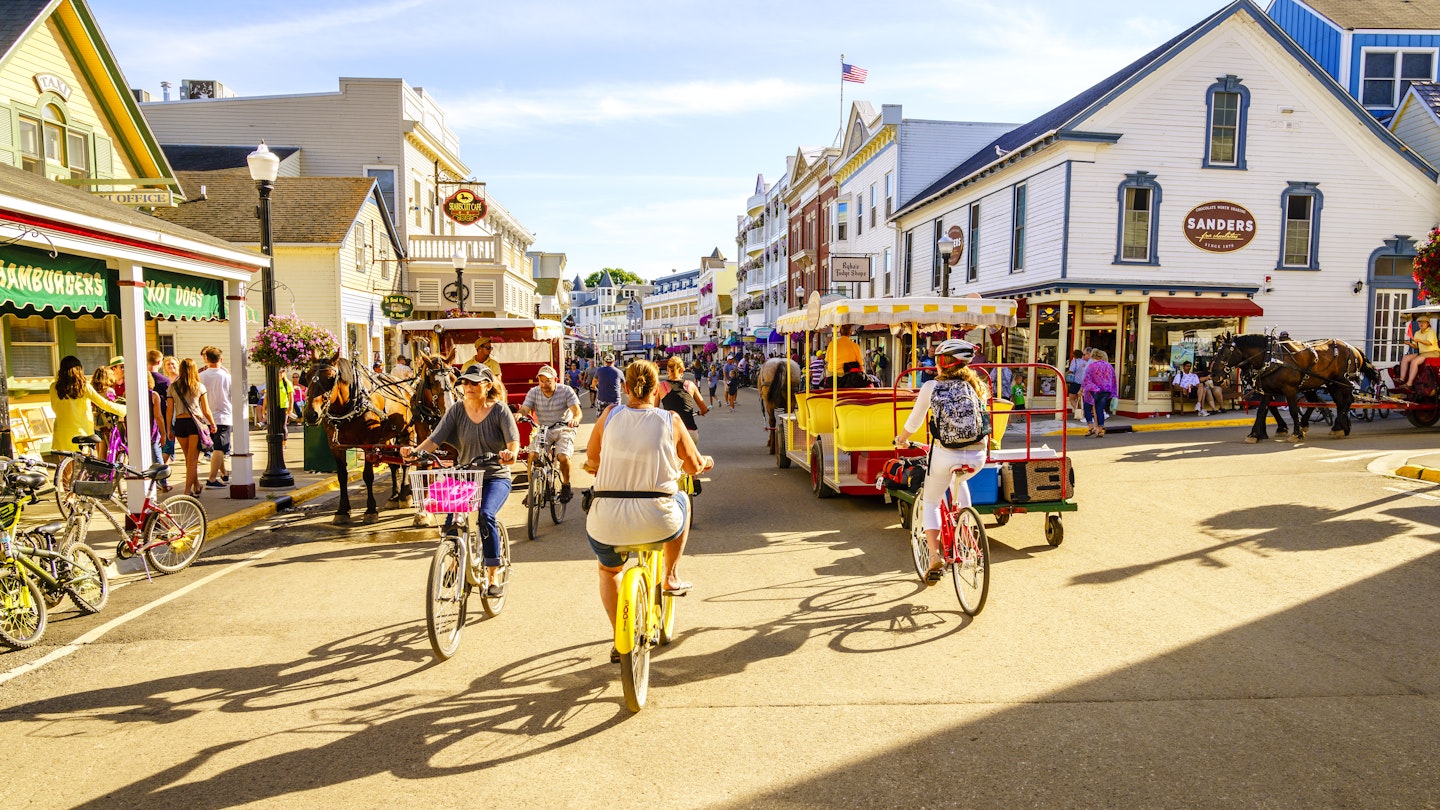 Mackinac Island, Michigan, August 8, 2016: Vacationers take on Market Street on Mackinac Island that is lined with shops and restaurants. No motorized vehicles are allowed on the island.
599741930
Vacationers cycling and walking along Market Street on Mackinac Island in Michigan.