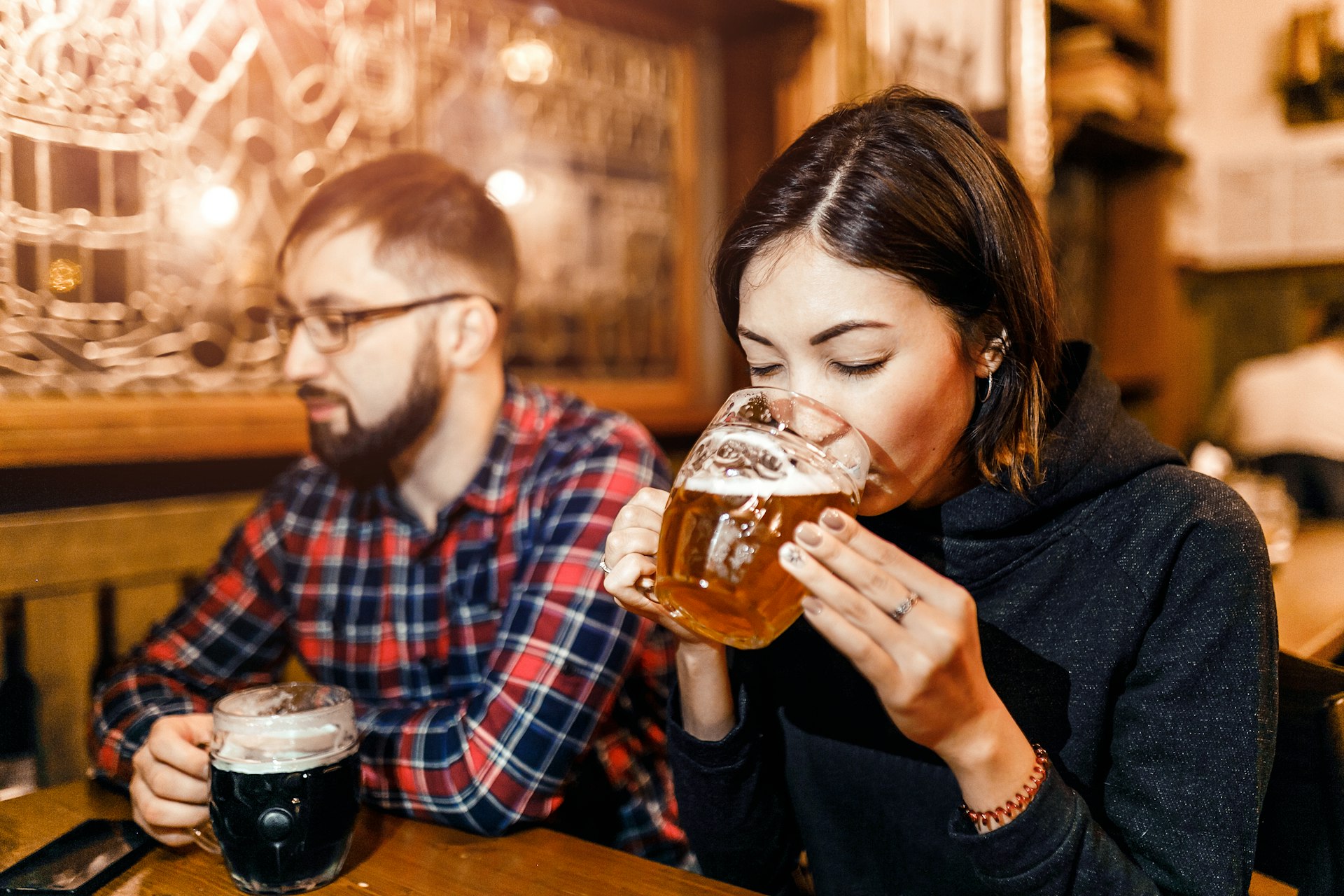 A woman and her friends try freshly brewed authentic Czech beer in a tavern in Prague
