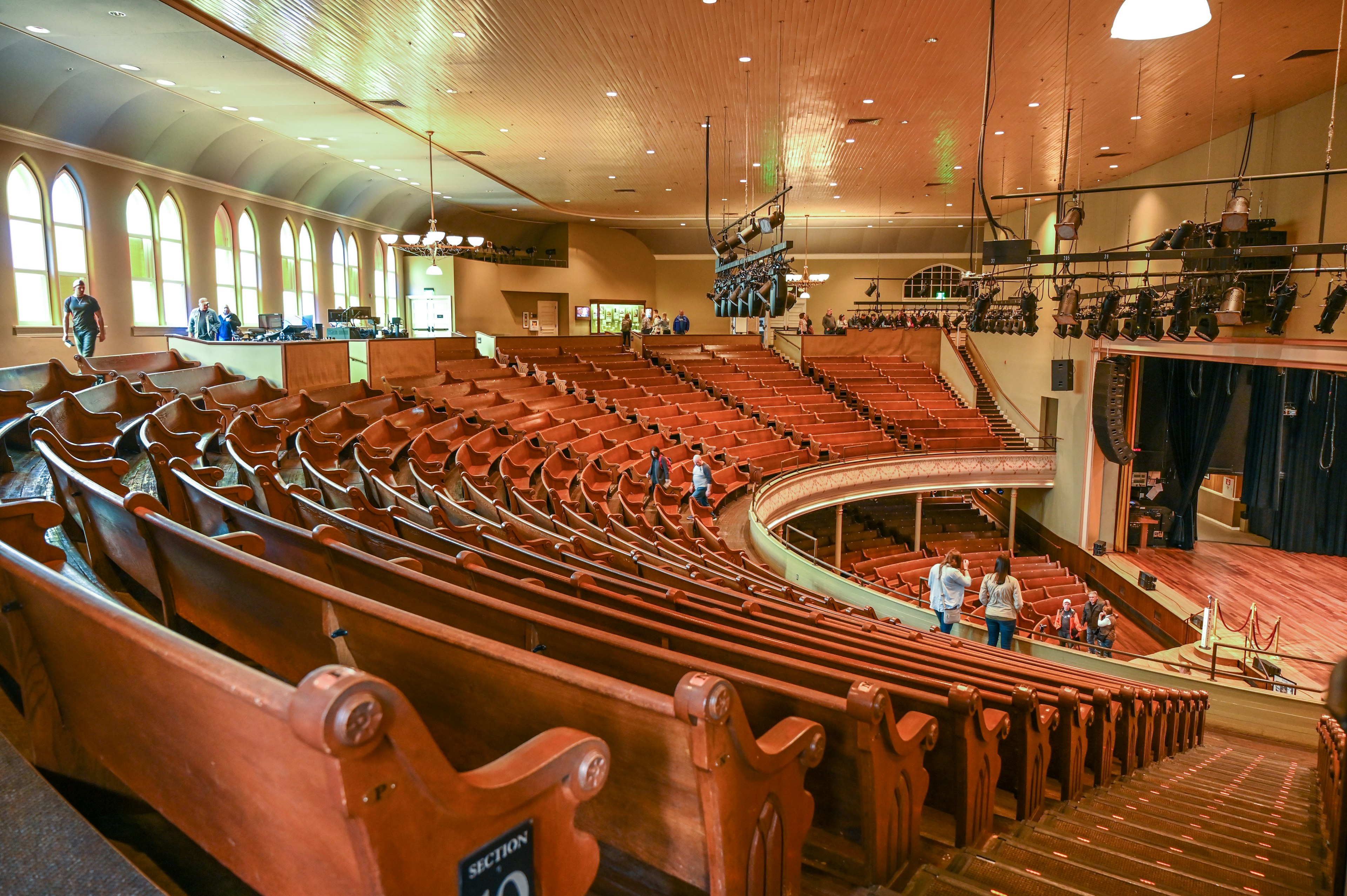 People stand among the wooden pews in the balcony at the Ryman Auditorium, Nashville.