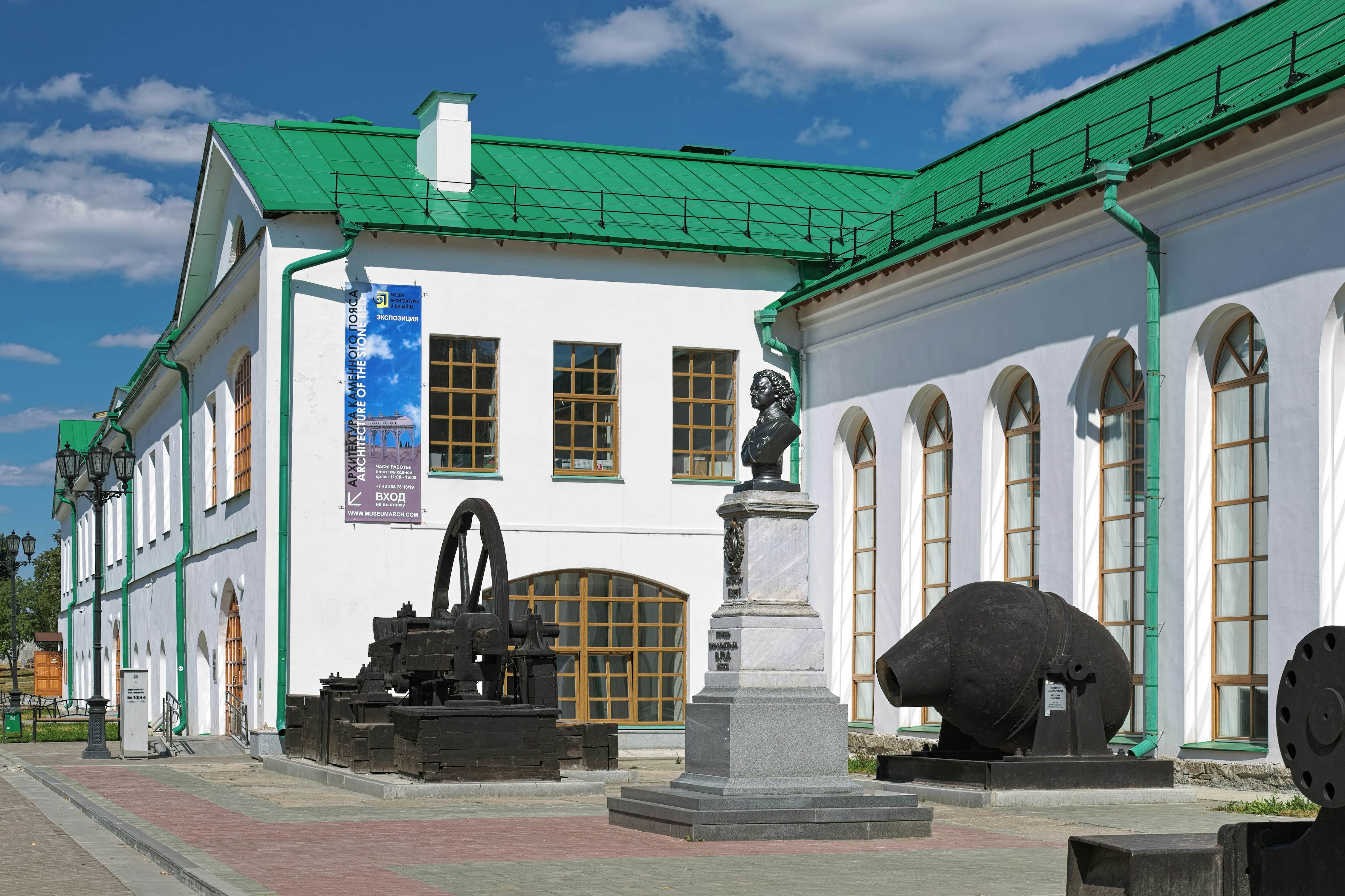 Bust of Peter I outside the Museum of Architecture and Design surrounded by iron plants equipment. 