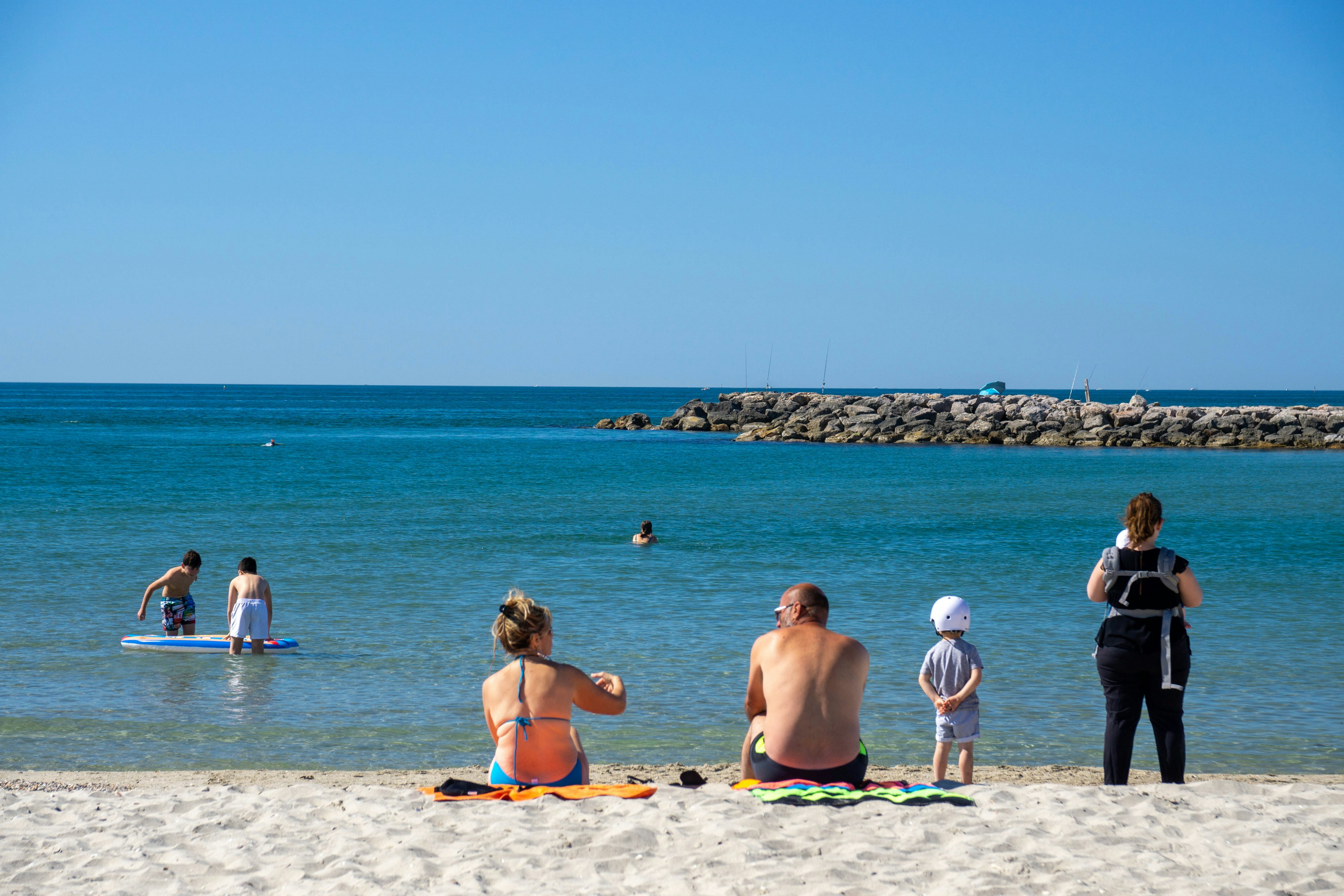 People in bathing suits on the beach on a sunny day