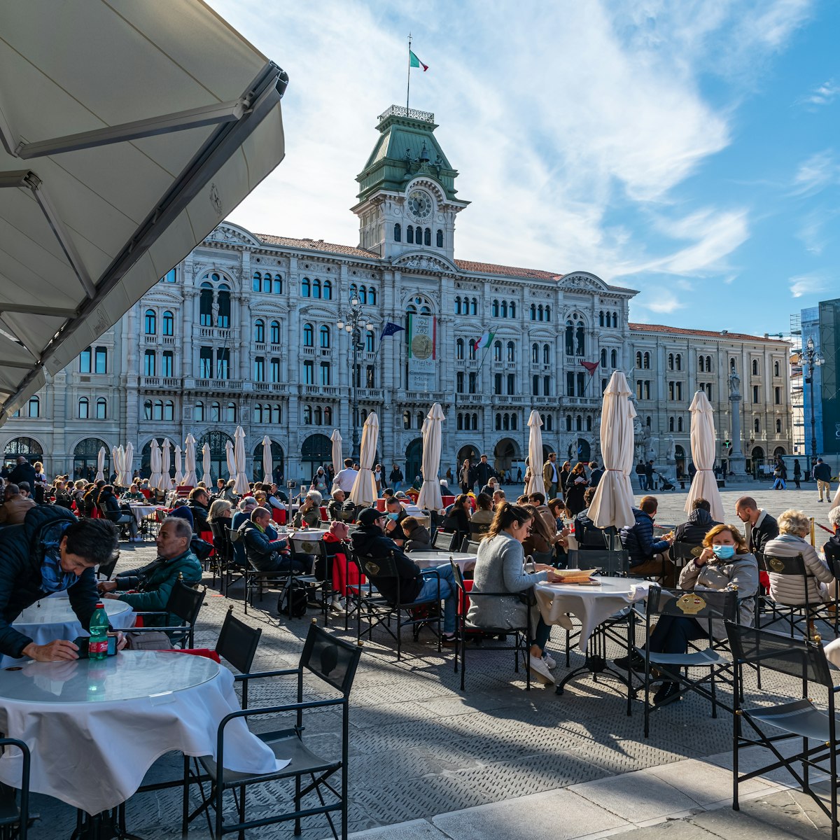 People enjoying coffee at a famous coffeeshop at the Piazza dell’Unità d’Italia, the main square in Trieste.