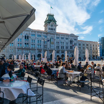 People enjoying coffee at a famous coffeeshop at the Piazza dell’Unità d’Italia, the main square in Trieste.