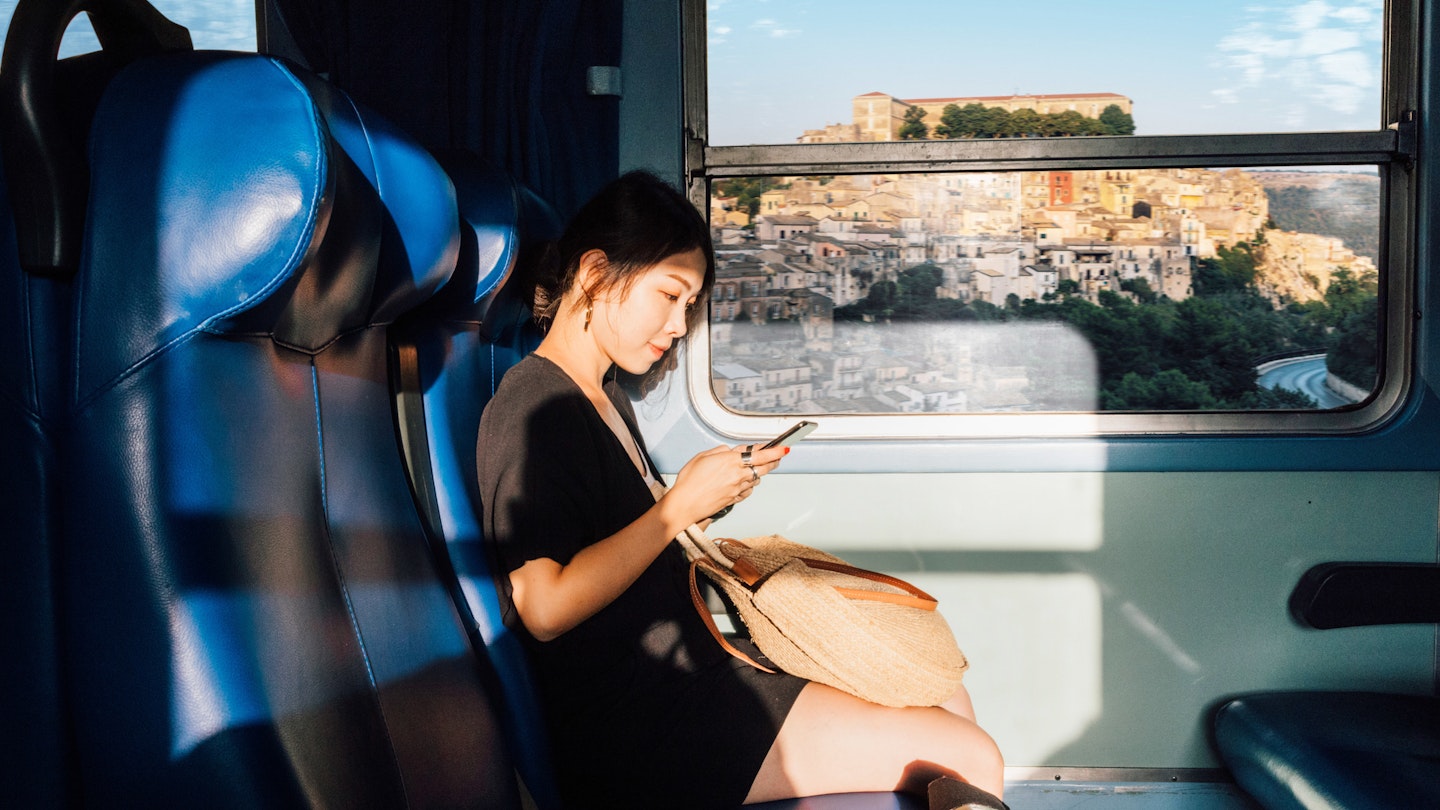 1202312137
A young East Asian woman using her phone on a train in Sicily