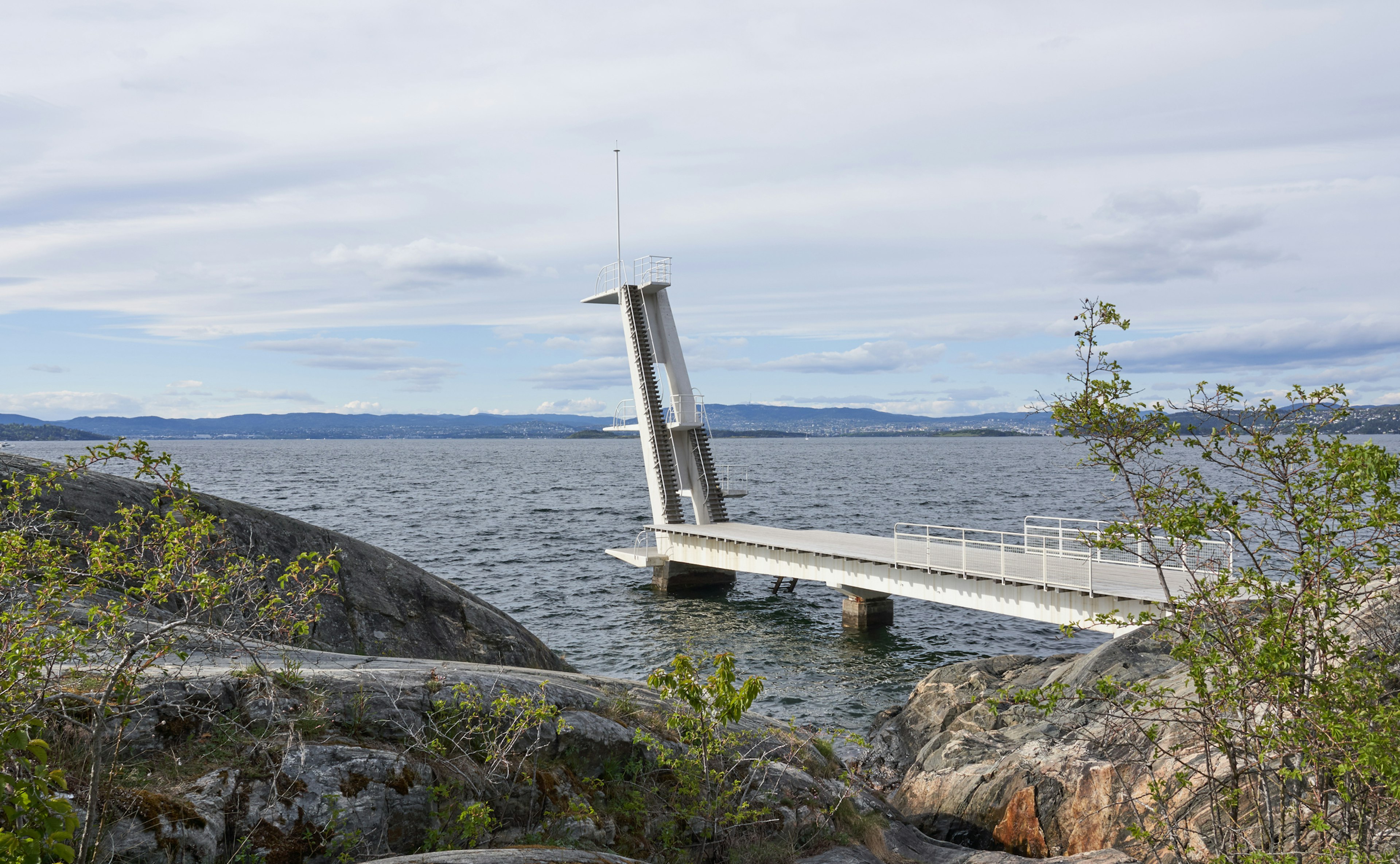 Diving board in Functionalism style and bare rock-face.