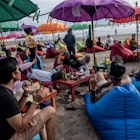 BALI, INDONESIA - JANUARY 28 : Tourists sit on the coloured beanbags under the Balinese umbrellas as they enjoy the sunset at a cafe on January 28, 2021 in Double Six beach, Bali, Indonesia. In Bali, famed among tourists for its beaches and sunsets, the northwest monsoon brings a different kind of arrival - vast amounts of plastic waste. From December to March, so much trash washes up on the beaches that the local government struggles to keep up and clean up. Locals and workers have together been collecting 80 tonnes of waste a day as it washes ashore at world-famous beaches from Seminyak to Kuta, the local government said. Almost 75 percent of it is plastic, according to a study by the Center of Remote Sensing and Ocean Sciences at Bali's Udayana University. In the absence of tourism due to Covid-19, the trash problem has become obvious on beaches almost entirely devoid of visitors. Indonesia is part of the U.N.'s Clean Seas campaign, which aims to halt the tide of plastic trash polluting the oceans. As part of its commitment, the government has vowed to reduce marine plastic waste by 70 percent by 2025. (Photo by Agung Parameswara/Getty Images)
1230981345