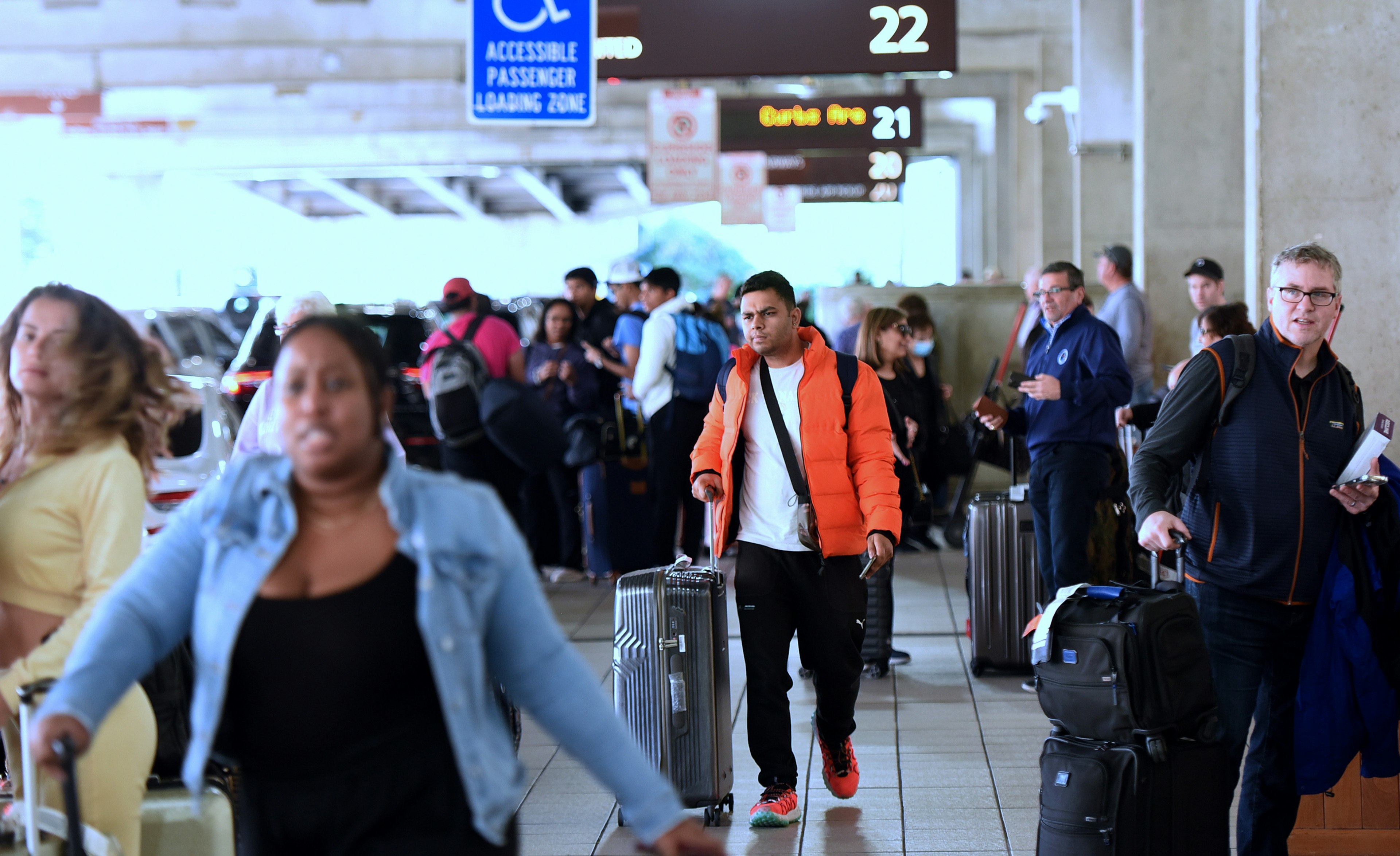 Arriving travelers wait for ground transportation at Orlando International Airport