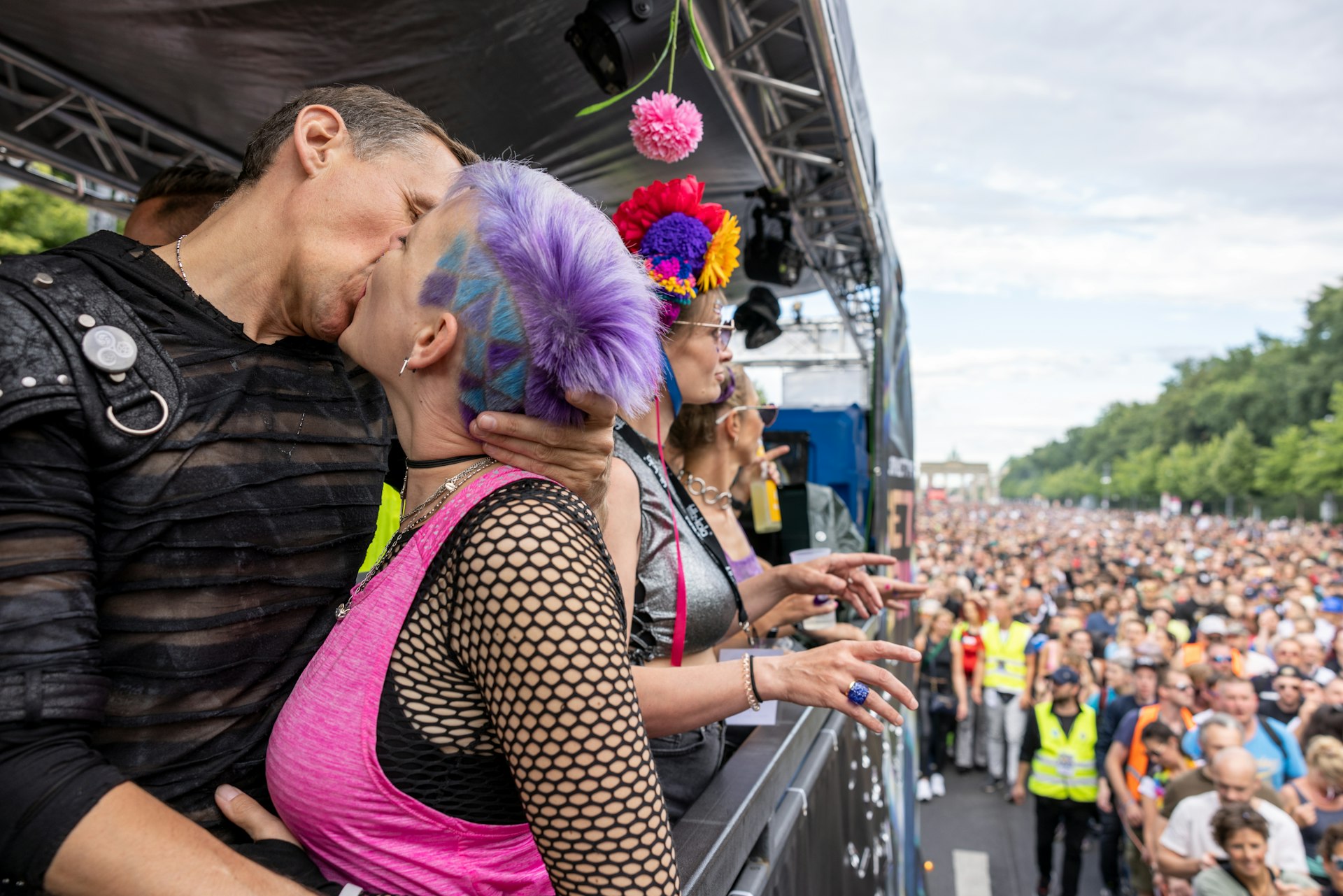 Two techno music enthusiasts kiss on a float at Rave the Planet (Love Parade) 2022, Berlin, Germany