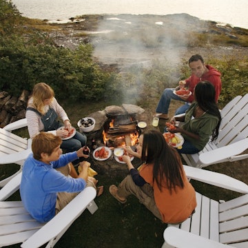 523414408
boyfriend:CB3, girlfriend:CB3, eating:CB3, friendship:CB2, fun:CB2, human relationships:CB2, African-American ethnicity:CB2, ethnic diversity:CB2, clambake:CB2, cooking fire:CB3, togetherness:CB2, 18-19 years:CB2, young adult man:CB2, young adult woman:CB2, talking:CB2, view from above:CB1, recreation:CB2, Caucasian ethnicity:CB2, coast:CB2, dinner:CB3, adirondack chair:CB2, summer:CB2, 20-24 years:CB2, outdoors:CB2, lobster:CB2, lifestyle:CB2, evening:CB2, socializing:CB3, lake:CB2, picnic:CB2, five people:CB1, full-length:CB2, Maine:CB2
A group of friends cooking seafood over a fire outdoors in Maine