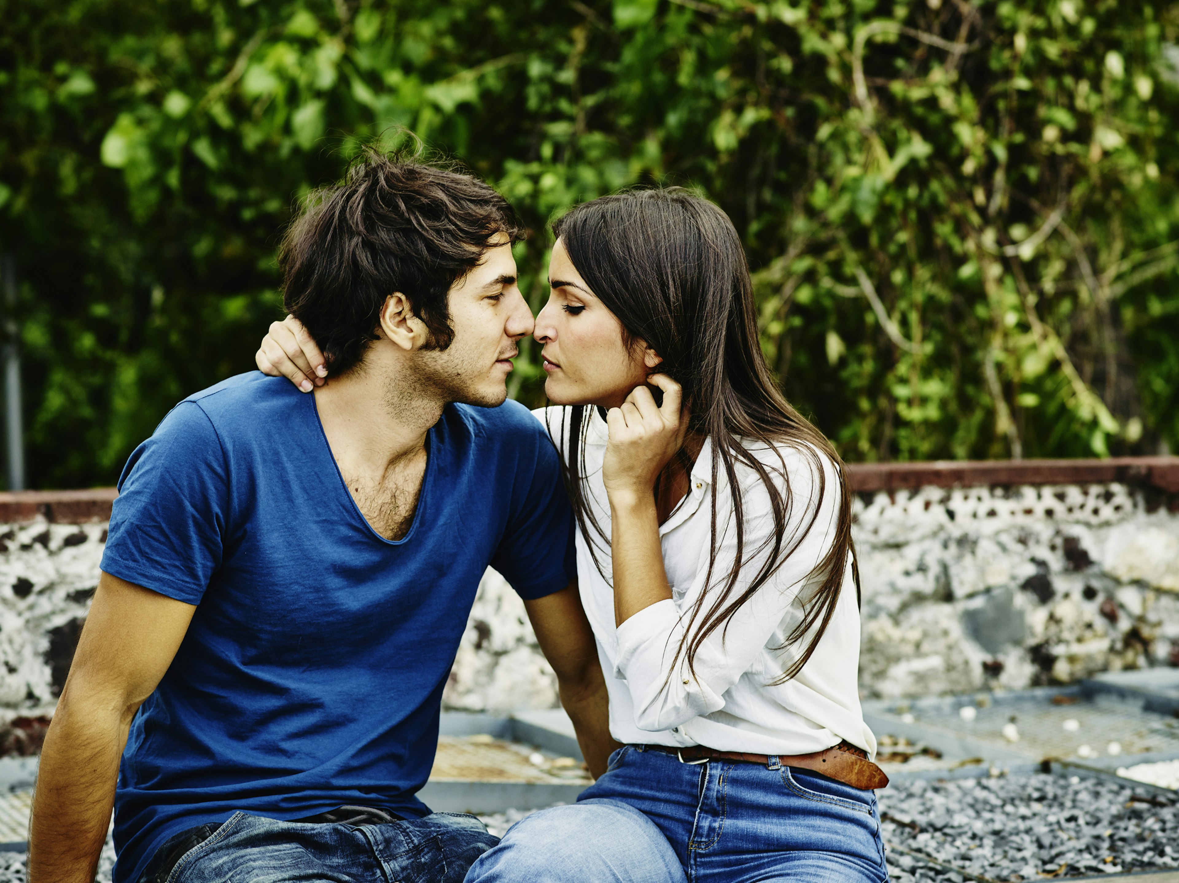 Man and woman sitting together about to kiss on rooftop terrace in Mexico City