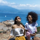 Horizontal picture of two girl friends laughing by the sea side
909521922
Two women laughing together on hilltop overlooking the coast in Italy
