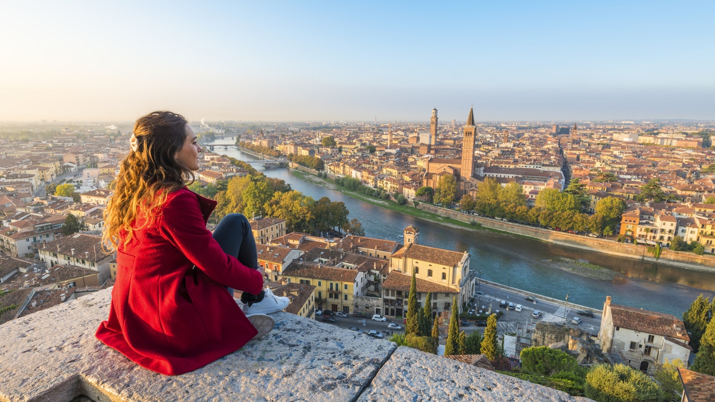 922099688
A young woman admires the view of Verona old town from Castel San Pietro