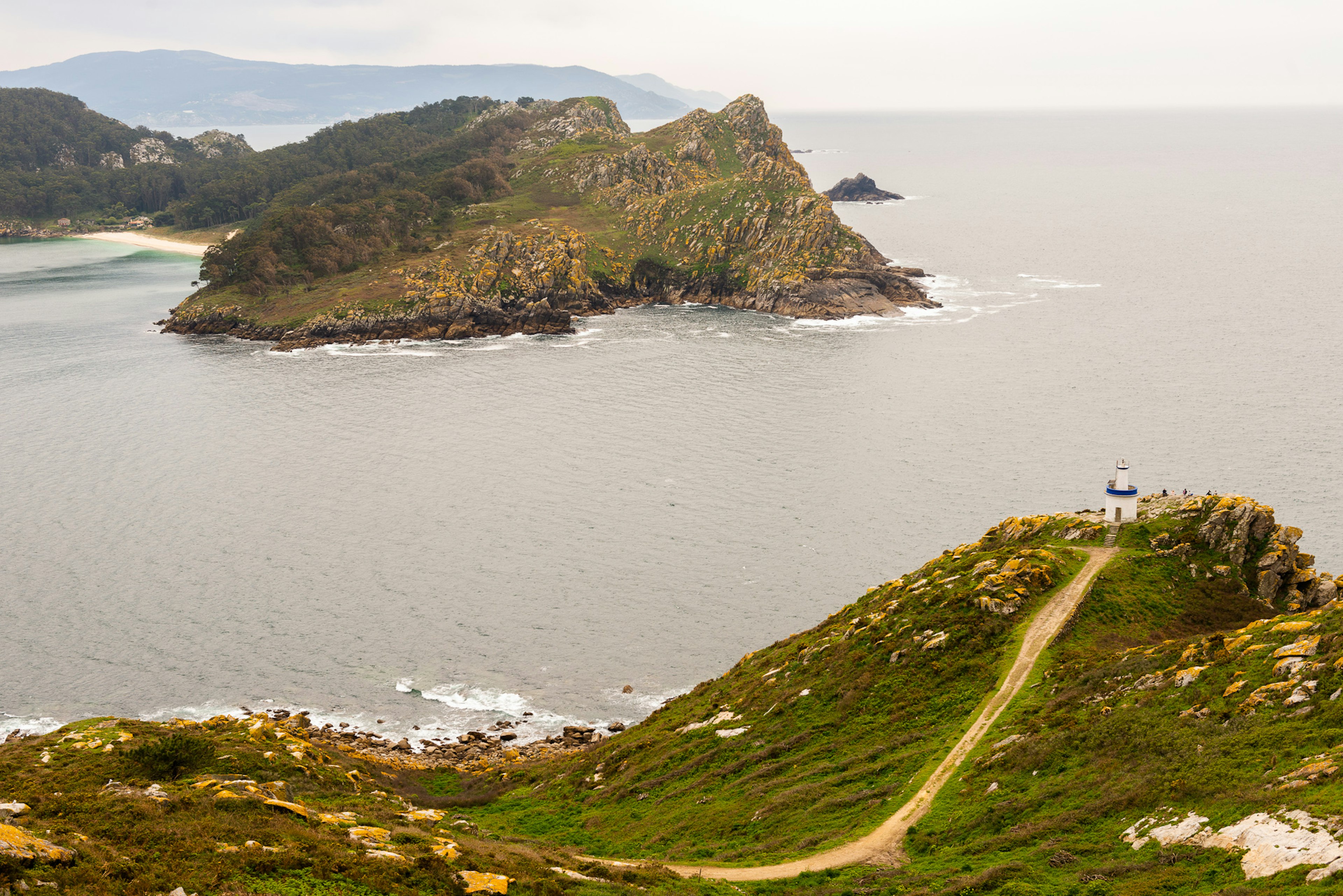 A rocky coastline with a cliff topped by a lighthouse