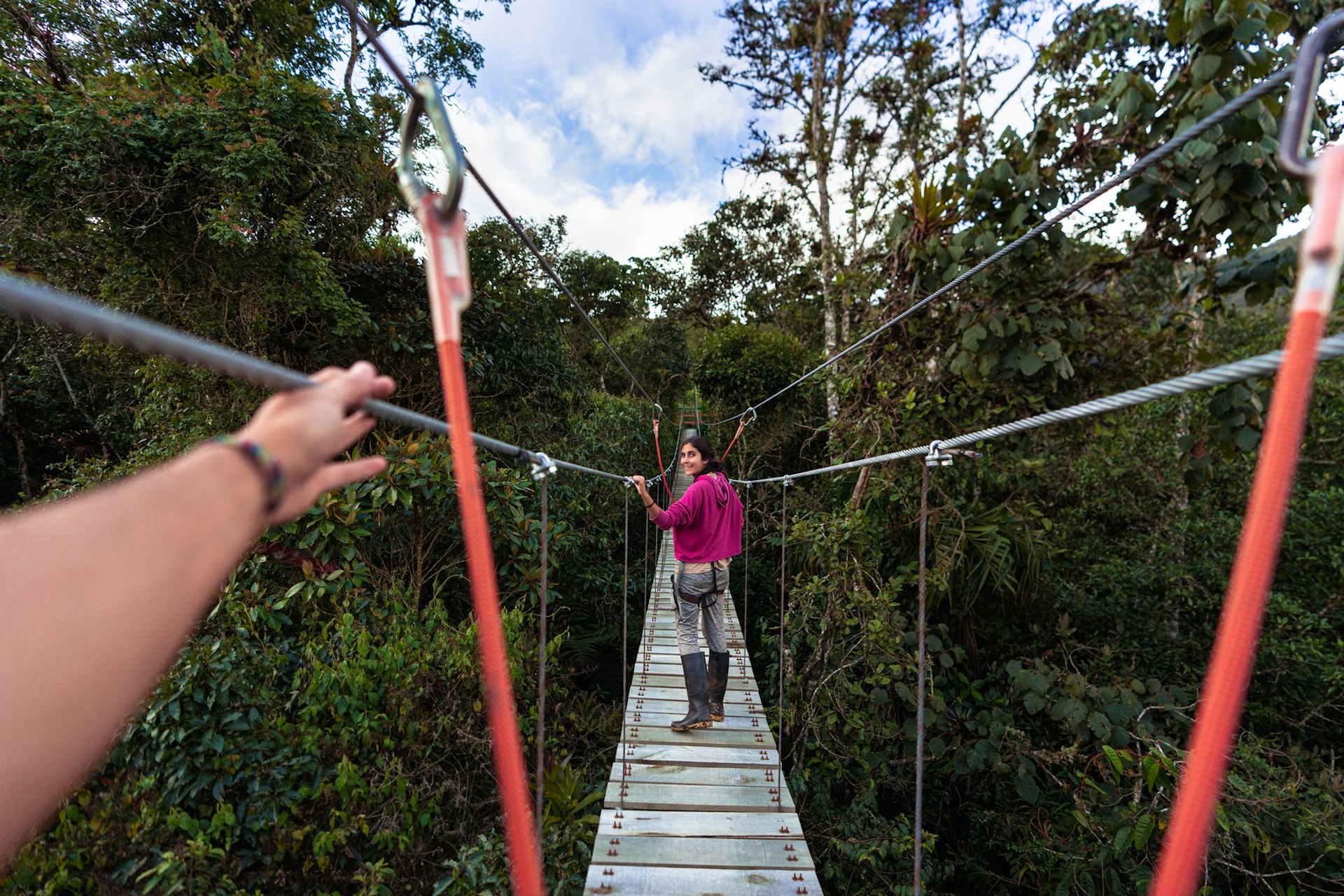 A woman crosses a hanging rope bridge in Costa Rica, Central America