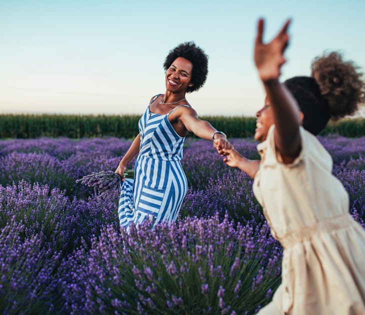 Afro mother and her daughter bonding together outdoors at the lavender field
