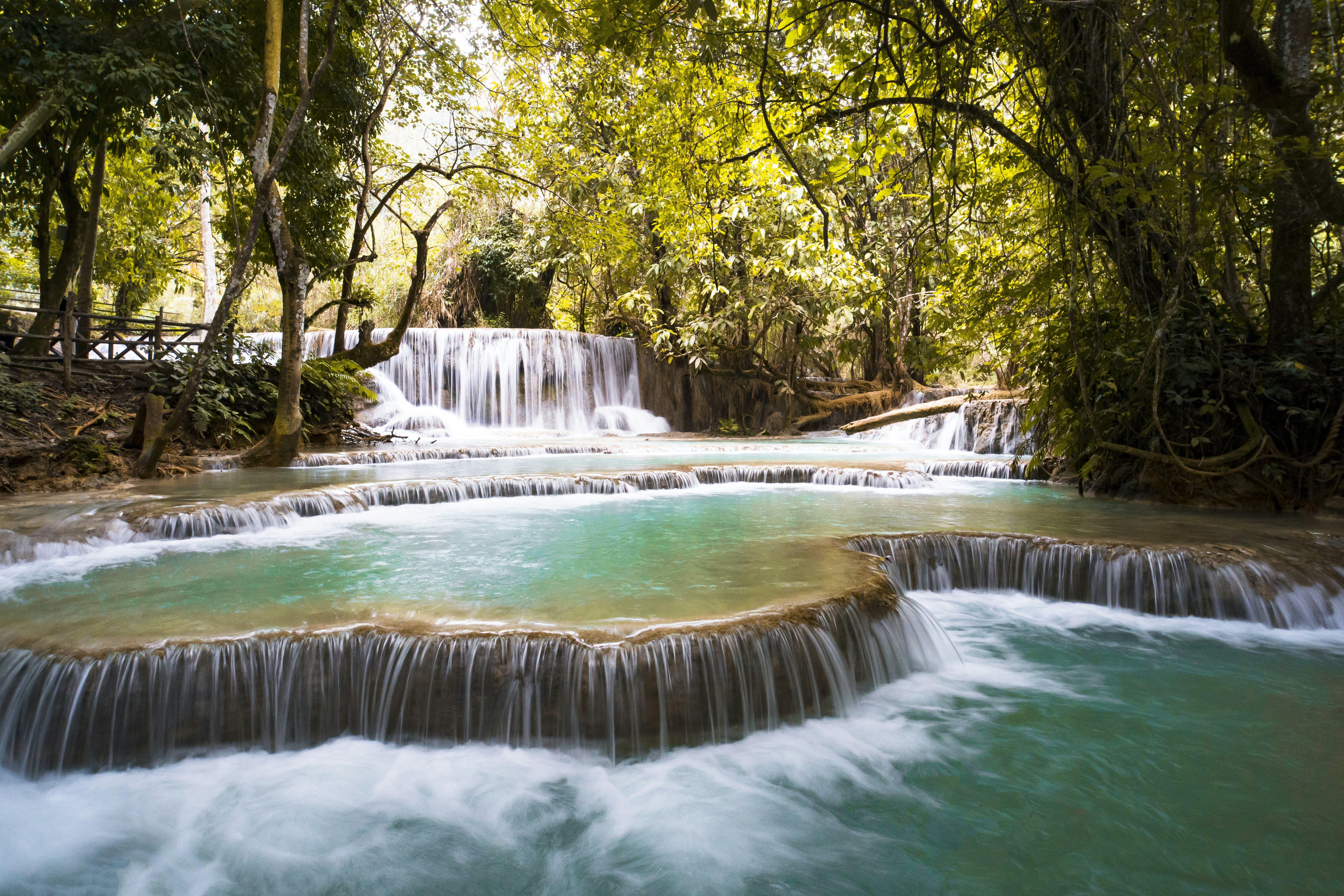 A waterfall surrounded by jungle cascades into a series of turquoise pools.