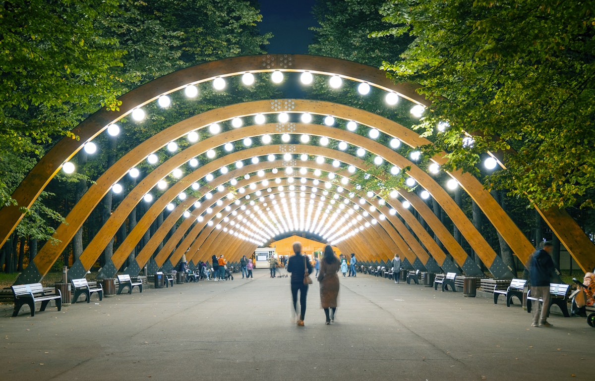 The main wooden arch with light and walking people in Sokolniki park, Moscow,  Russia.