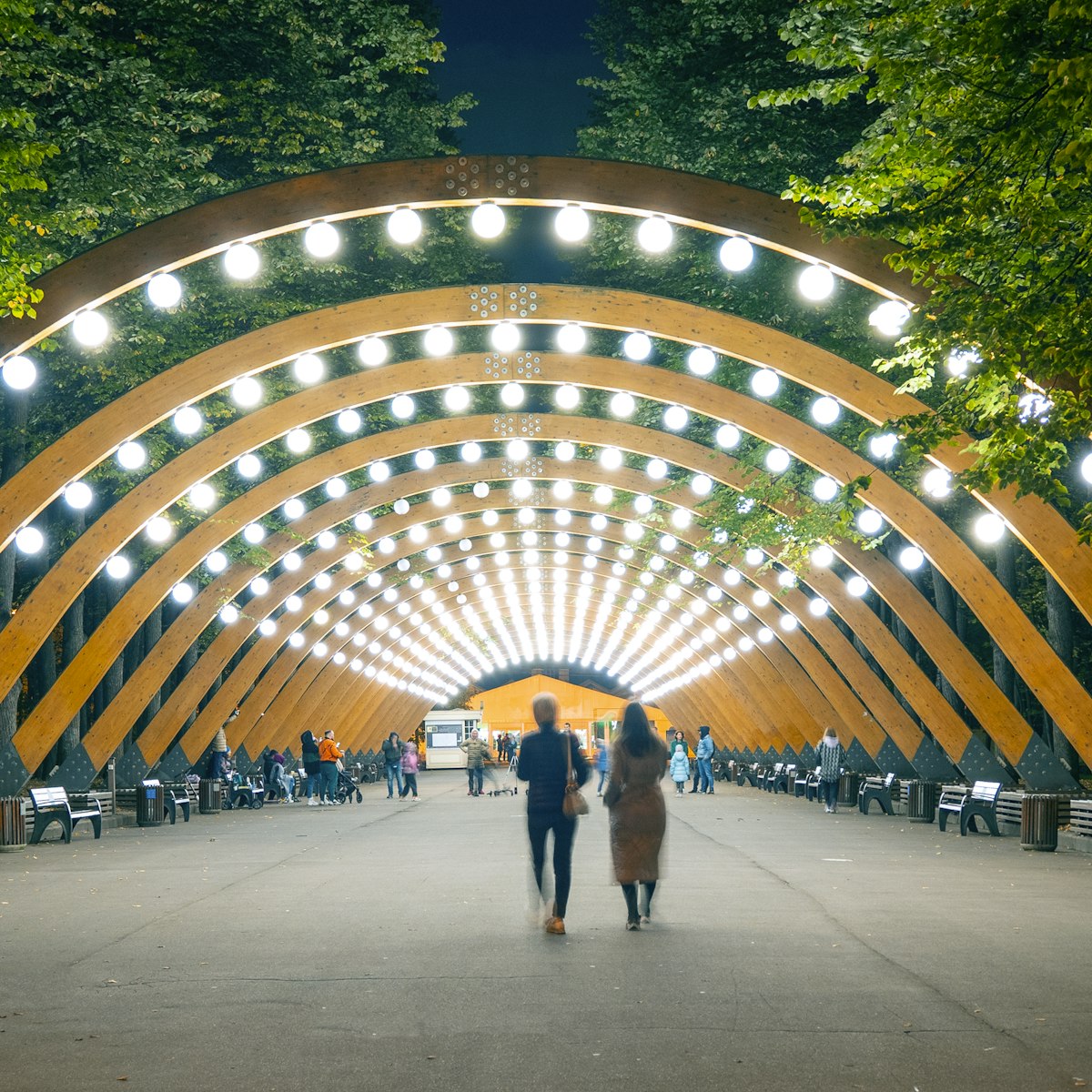 The main wooden arch with light and walking people in Sokolniki park, Moscow,  Russia.