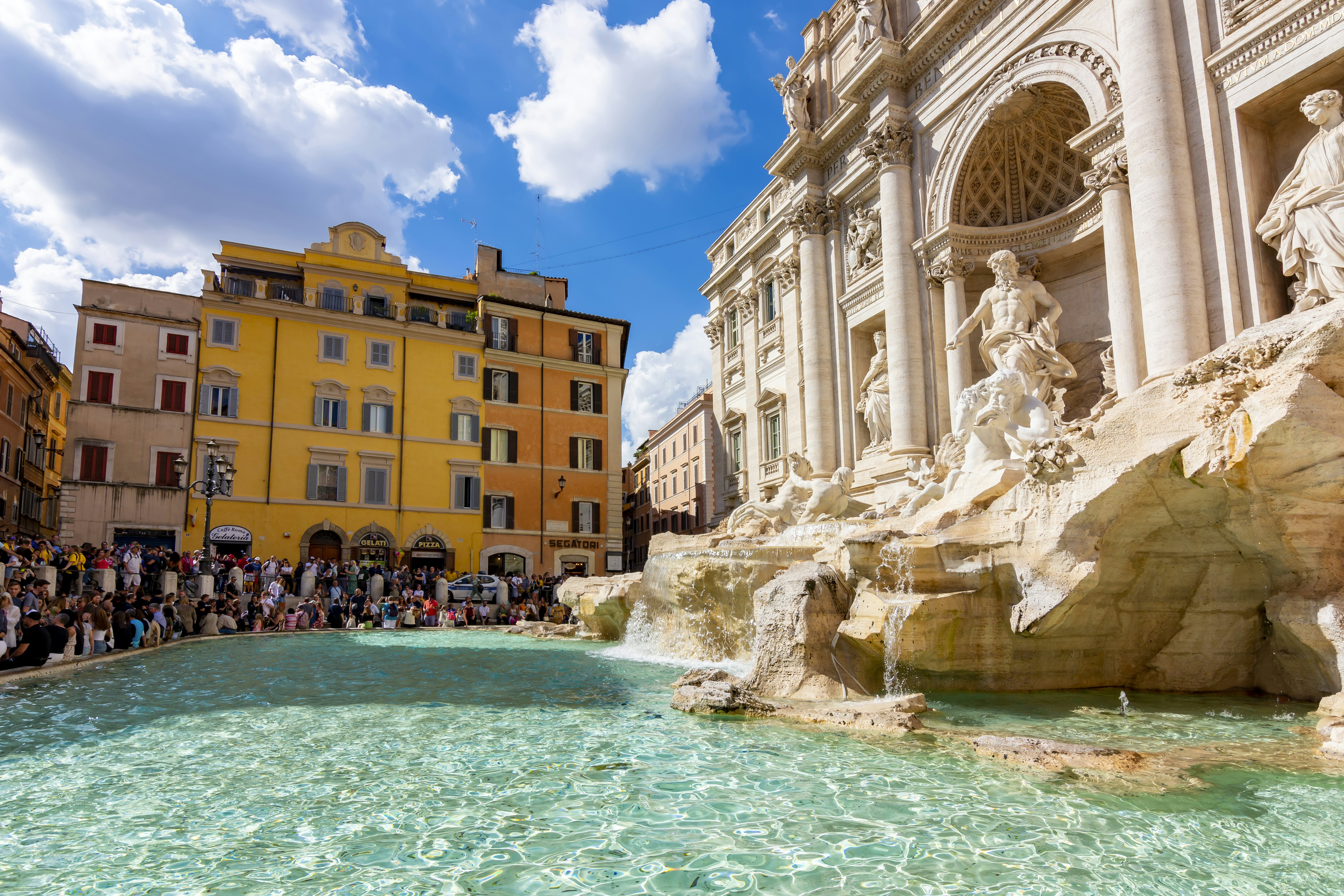 Summer crowds around the famous Trevi fountain in Rome, Italy, in summer.