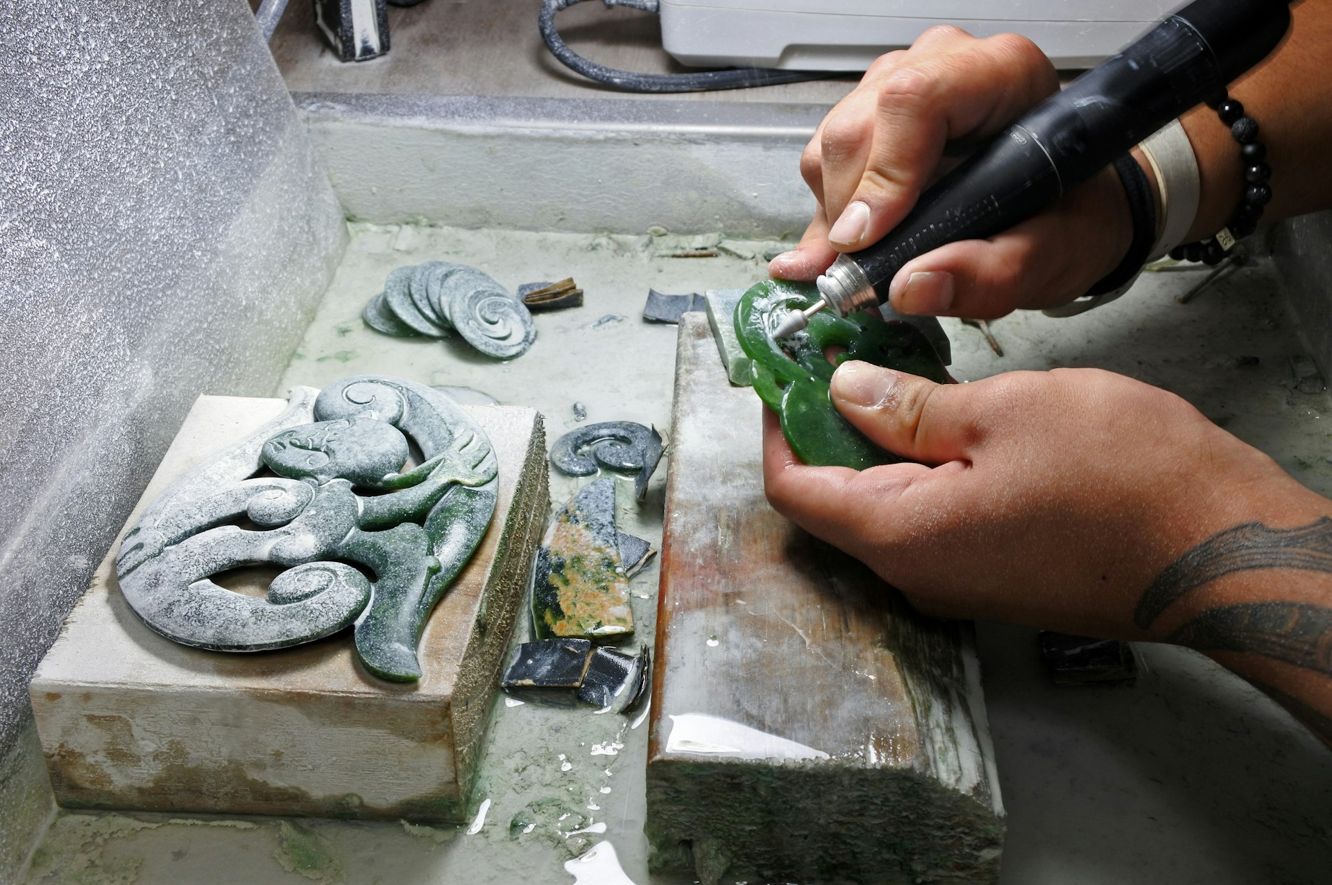 Hands of a man carving Jade ornaments in New Zealand