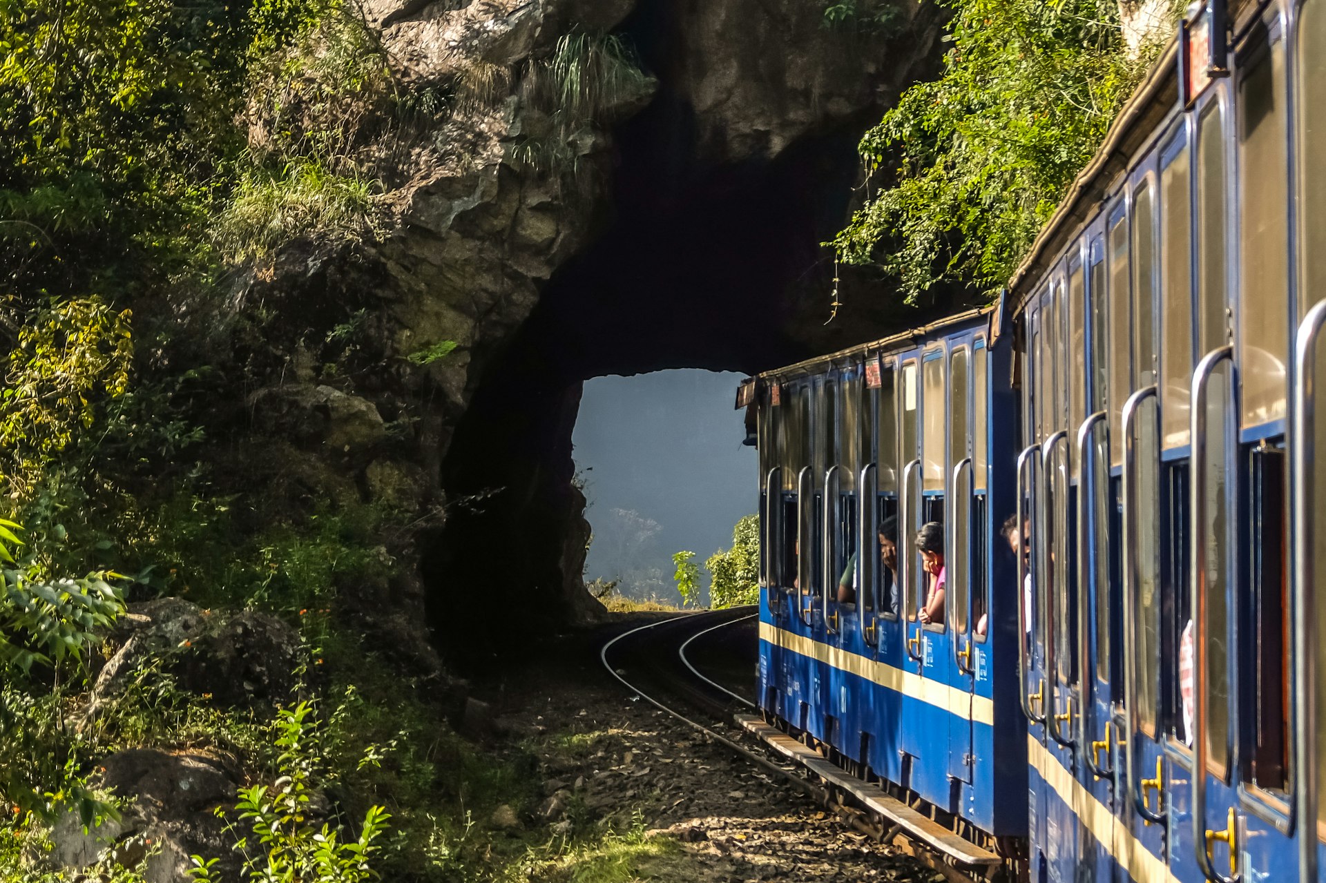 A Nilgiri Mountain Railway train leaves a narrow tunnel between Mettupalayam and Udagamandalam in South India