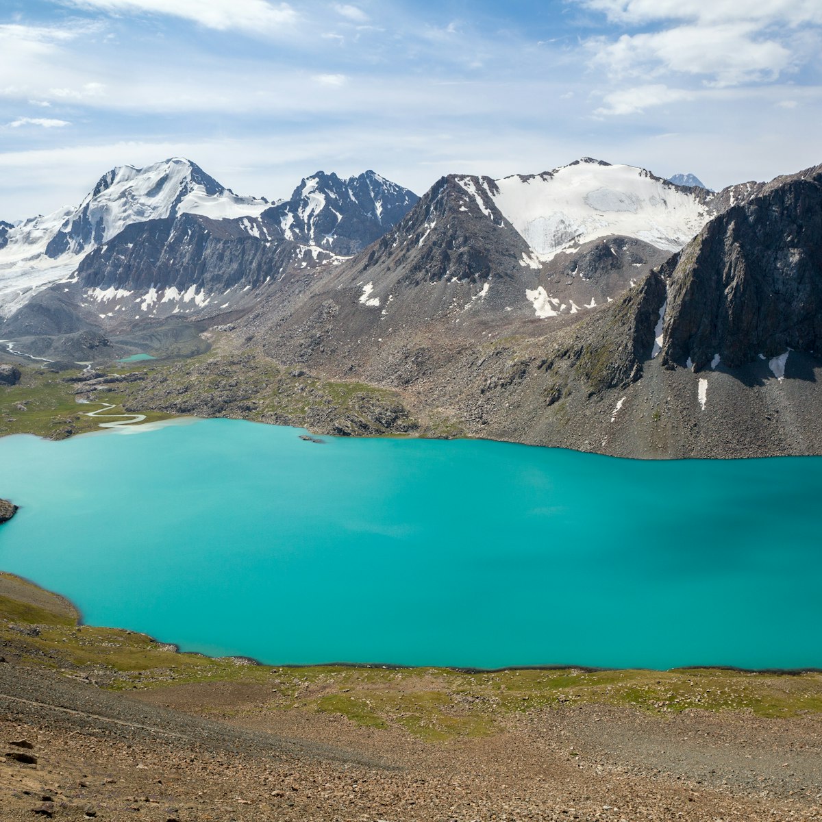Ala-Kul lake and snow-capped mountains in Kyrgyzstan.

