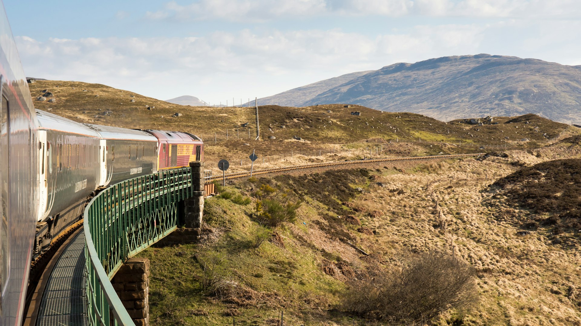 The Caledonian Sleeper train crosses Rannoch Viaduct on the scenic West Highland Line railway in the Scottish Highlands.