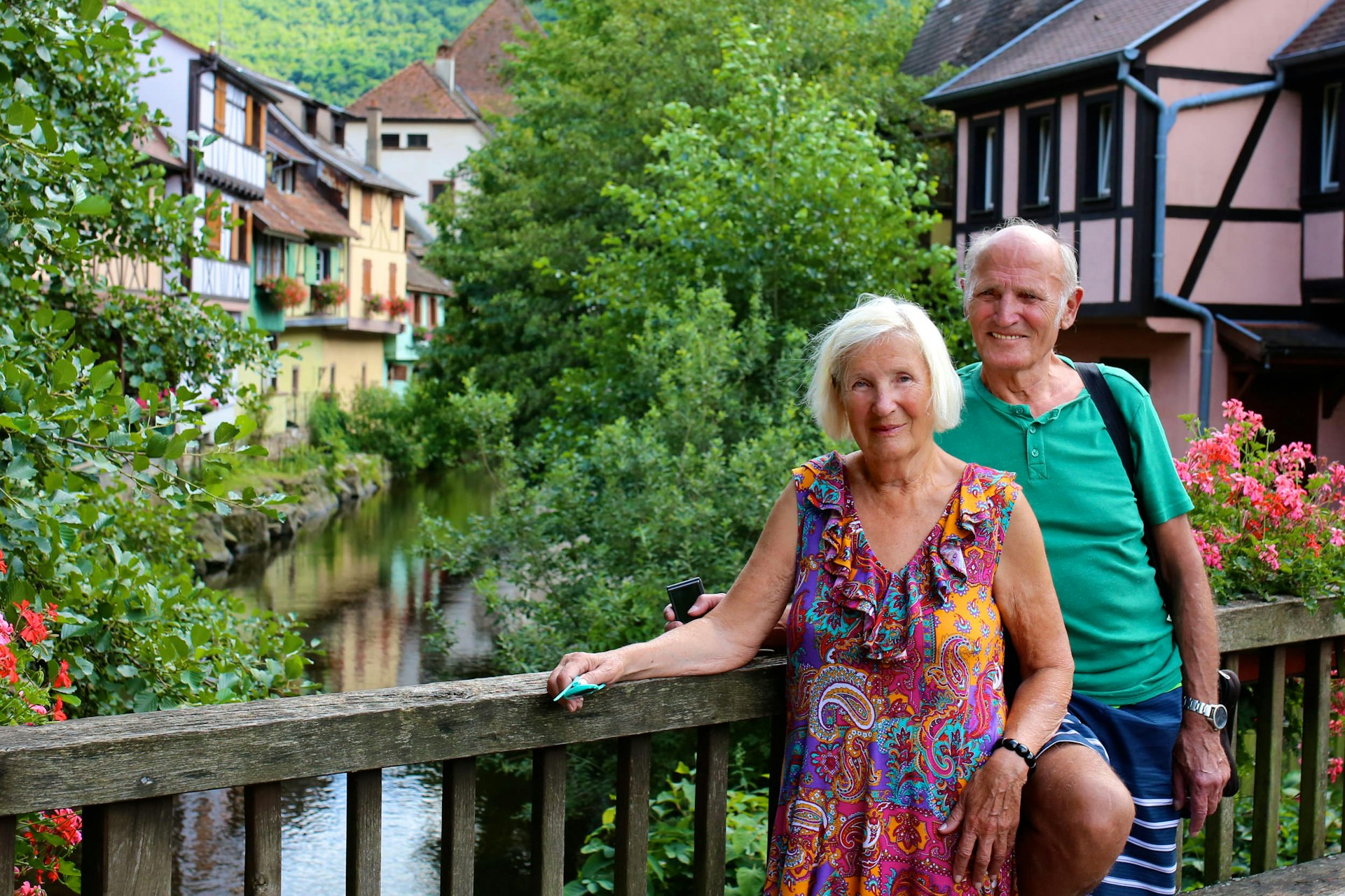 An elderly couple on a bridge in the streets of Kaysersberg town France