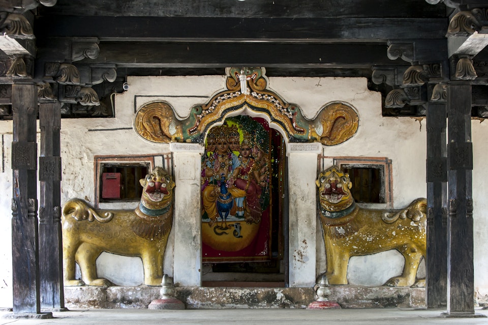 The entrance to the main shrine at Embekka Devale is located at the end of the digge (drummers pavilion) through a door guarded by lion statues.