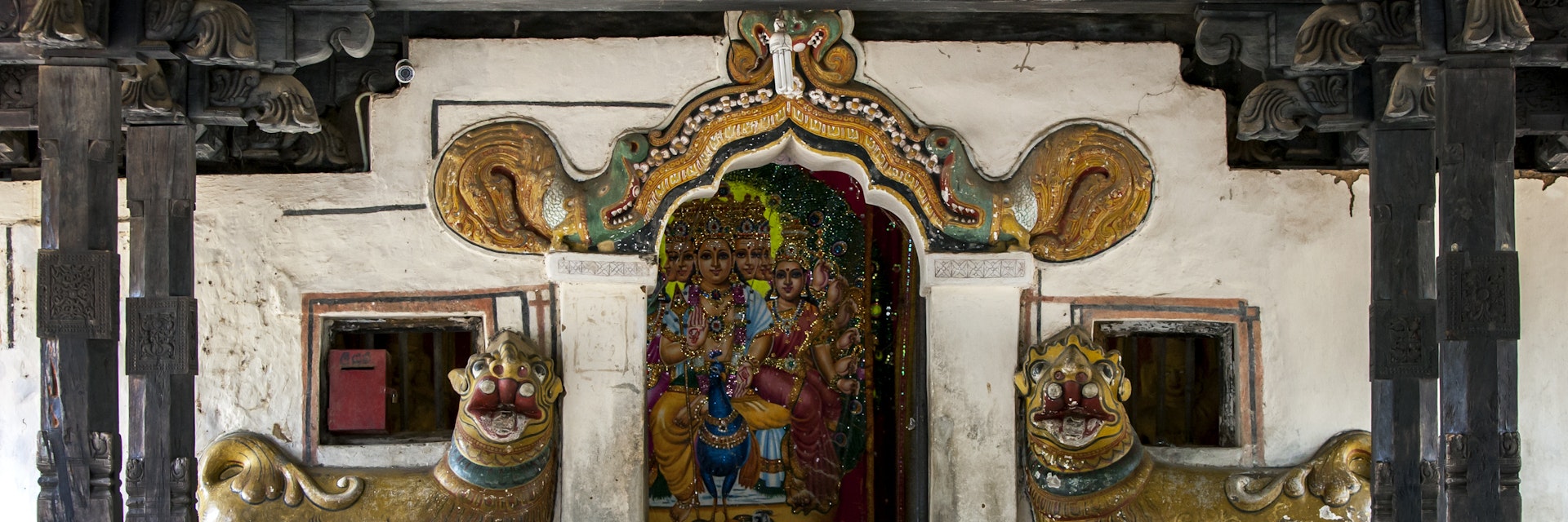 The entrance to the main shrine at Embekka Devale is located at the end of the digge (drummers pavilion) through a door guarded by lion statues.