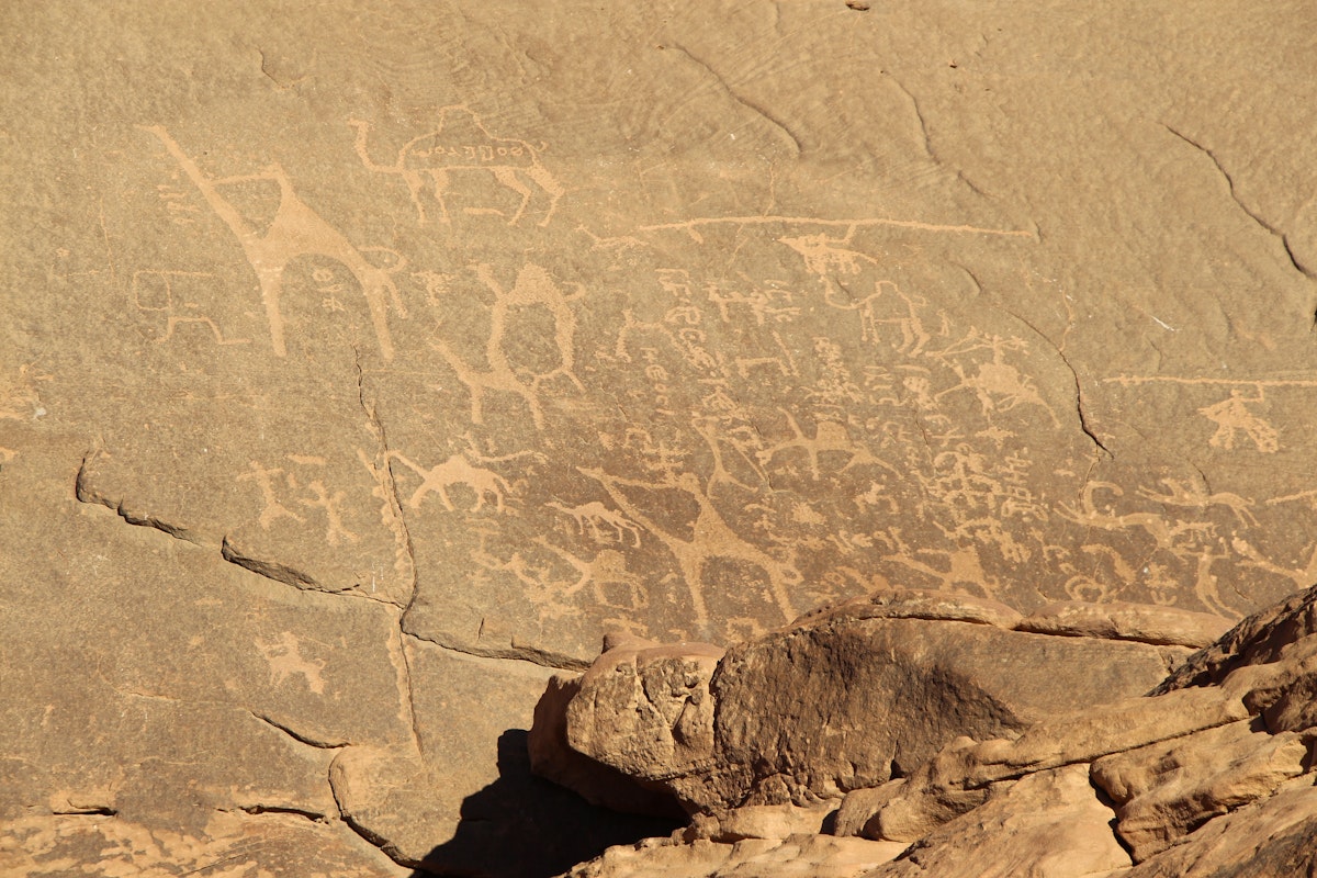 Petroglyphs (Alameleh inscriptions) of a caravan of camels on the sandstone rock in Wadi Rum desert in Jordan.