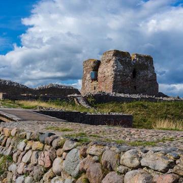 The remains of the historic danish fortress known as "Kalø Slotsruin" from the bridge leading to the old entrance with the big tower still standing tall.