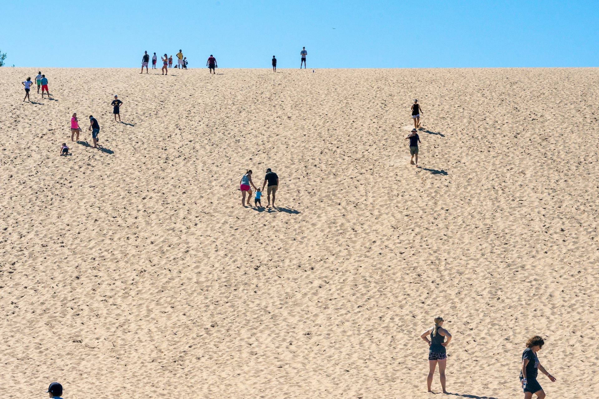 Visitors walk up and down Sleeping Bear Dunes to and from Lake Michigan