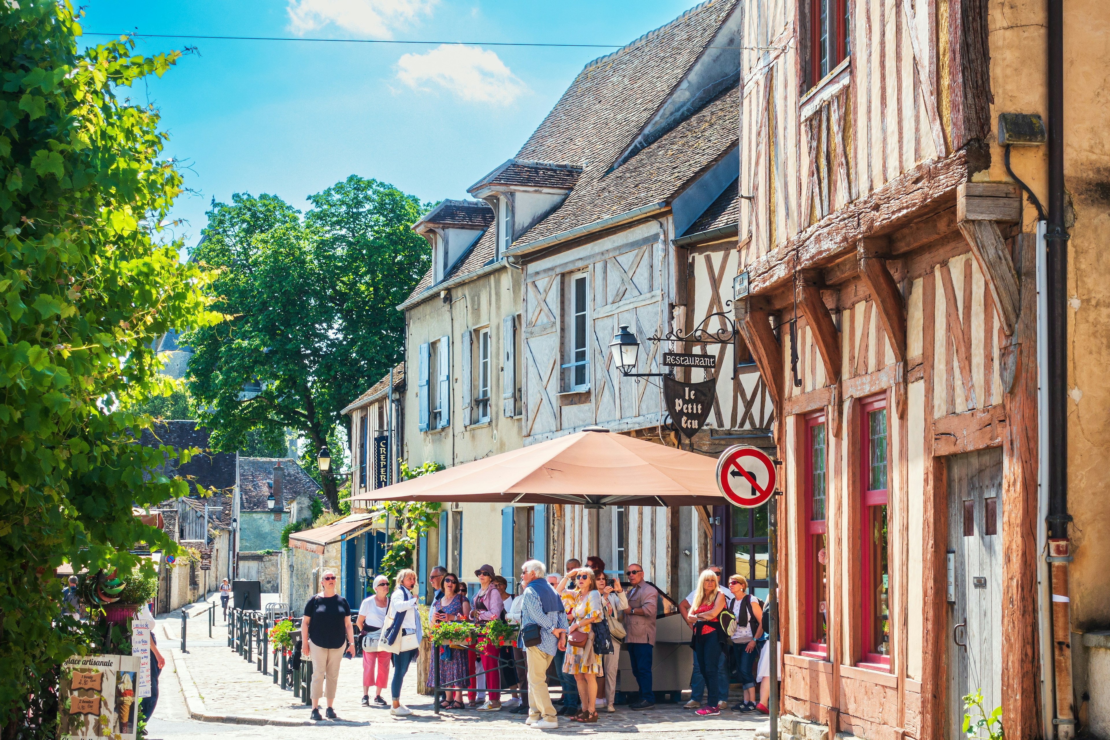 Tourists walk beside medieval buildings in Provins, France