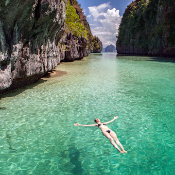 A woman floats on her back in the Big Lagoon on Miniloc Island.