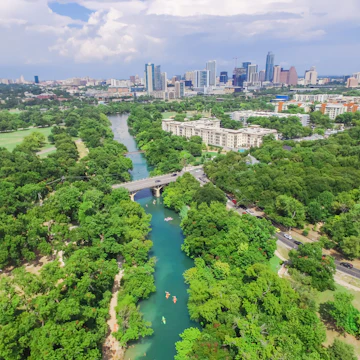 Aerial view Downtown from Barton Creek in Greenbelt at Zilker Metropolitan Park south Austin with summer blue cloud sky. Located at eastern edge of Hill Country, Austin the state capital of Texas, US.