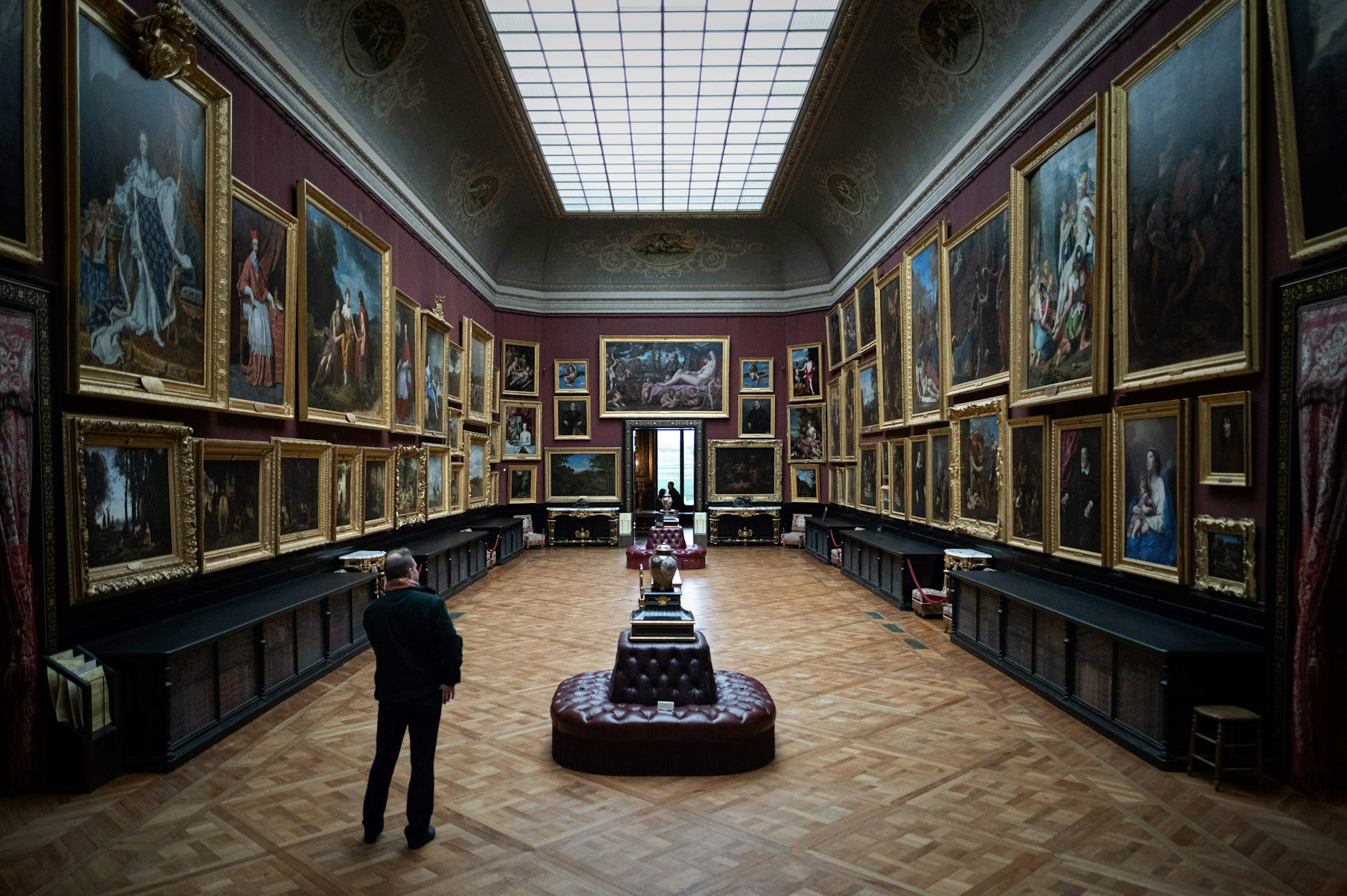 A visitor looks at paintings at the Château of Chantilly, Chantilly, Oise