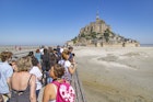 Lines of tourists and visitors waiting to board the bus towards the parking or arriving and walking towards the island. Mont-Saint-Michel tidal island with the magnificent medieval monastic buildings and the Abbey of Saint Michel with the statue of Archangel Michael atop the spire, in Normandy, France. Le Mont Saint Michel is a UNESCO World Heritage Site since 1979 and second most visited monument in France. The holy island with its breathtaking bay is a major Christian pilgrimage site destination for Europe for centuries. The Mont-Saint-Michel is one of Europes most unforgettable sights. July 2022 (Photo by Nicolas Economou/NurPhoto via Getty Images)
1242376118
brittany, world heritage, religious, wall, destinations, exterior, world, bridge, st michel, crowd, panorama, reflections, saint michel, vacation, site, attraction, michael, fortification, mont saint michel, mont st michel, historical, building, gothic, walled, landscape, bretagne, famous, unesco, mont-saint-michel, fortress