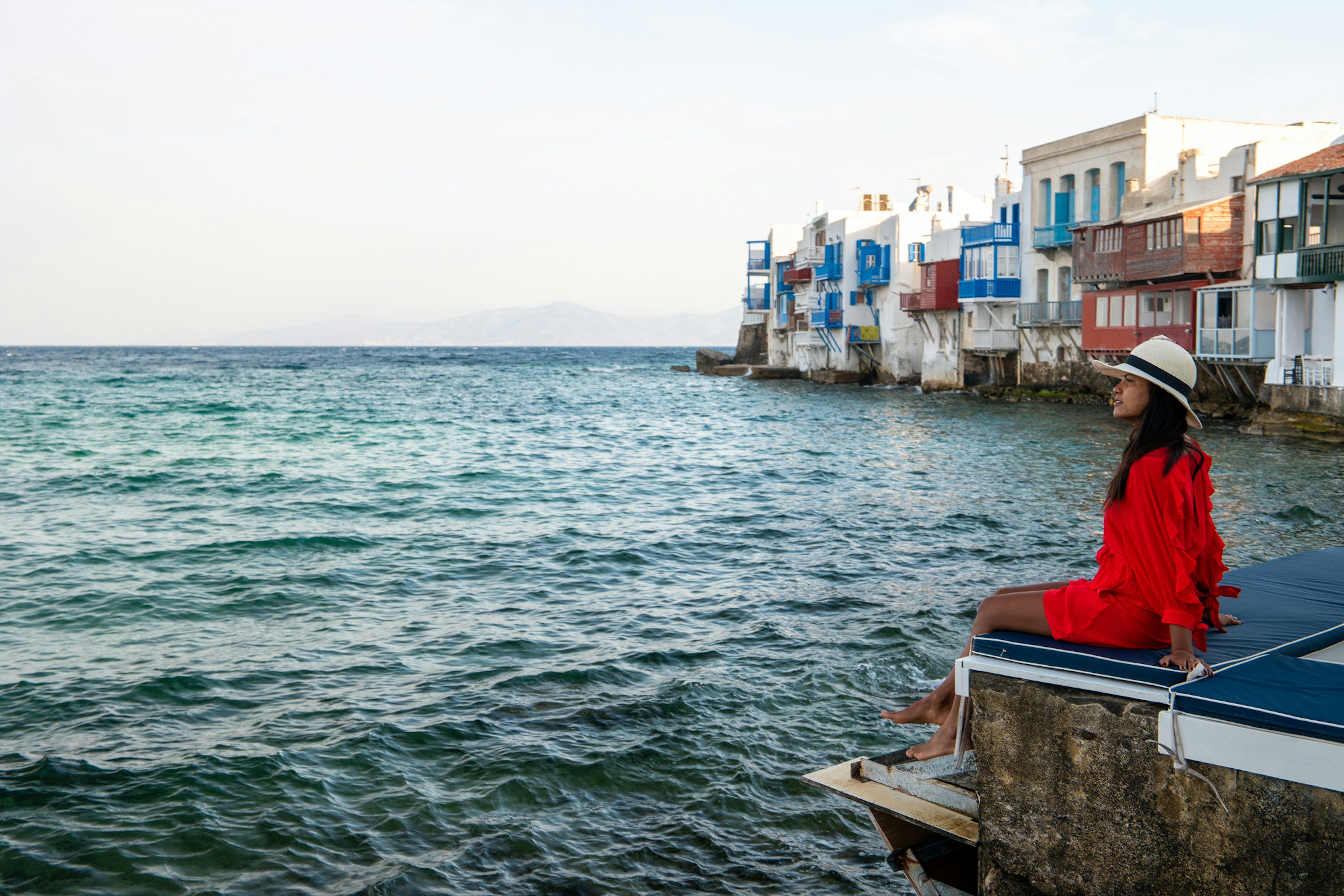 Mykonos Greece, woman on vacation at the Greek Island Mykonos, girl in dress at the white streets of little venice Mykonos Greece Europe