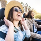 Happy couple driving convertible car enjoying summer vacation - Friends rent cabrio auto on holiday - Roadtrip, freedom, travel and transport rental service concept
1384618163
A smiling laughing couple driving a car in Spain