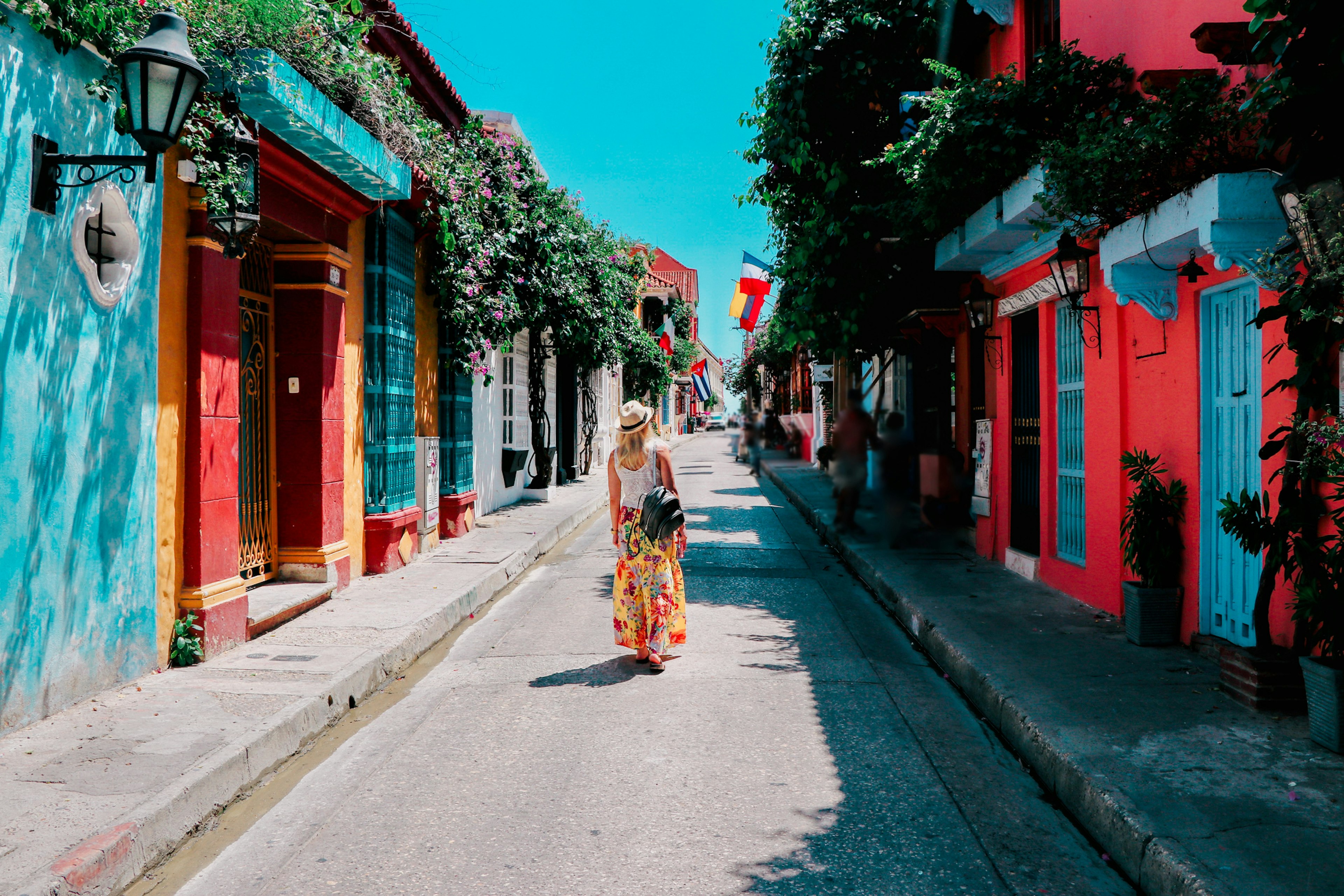 Young woman walking on a colorful street in the Old Town of Cartagena, Colombia