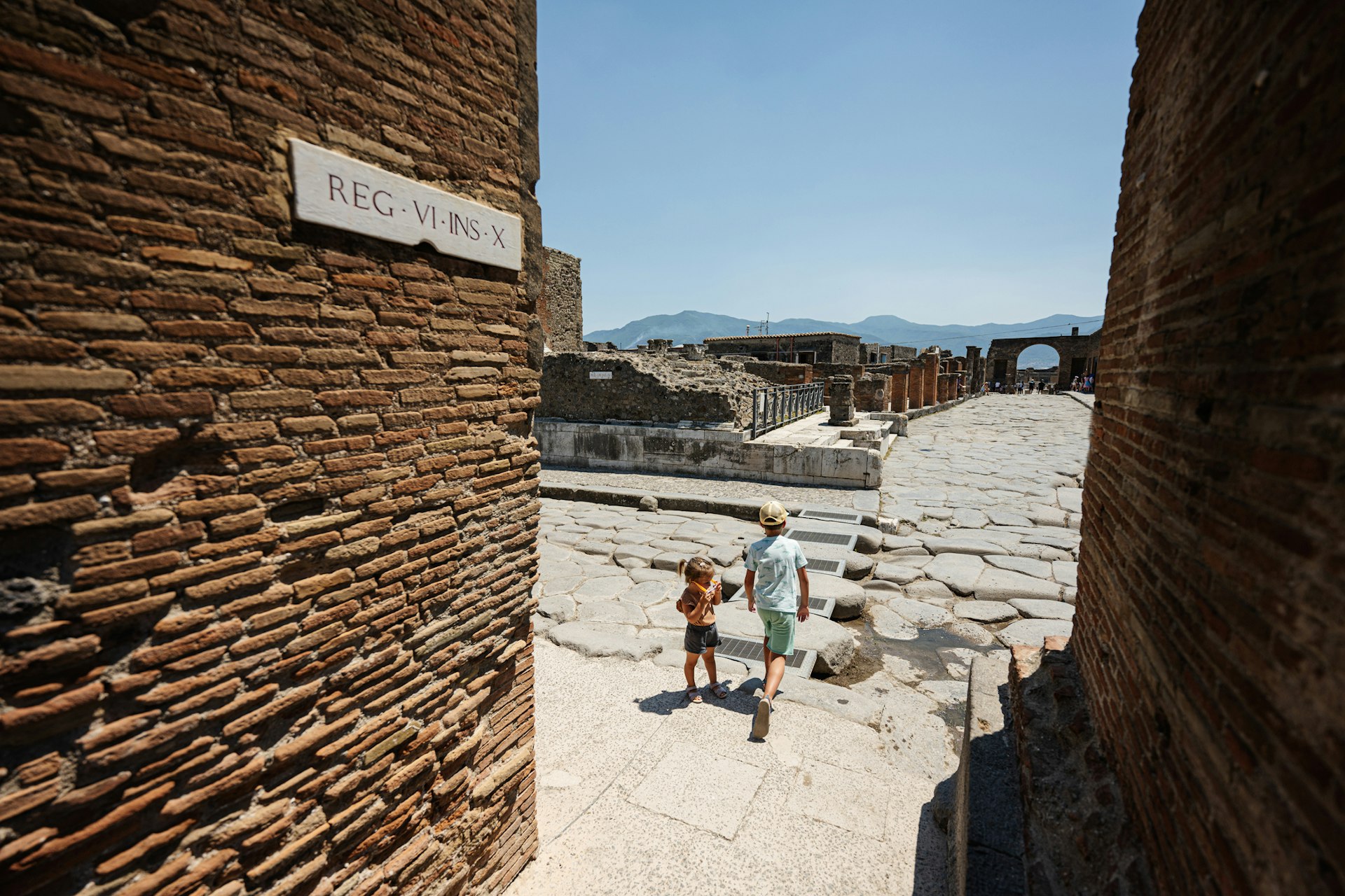 Two young tourists walk a path through an ancient city
