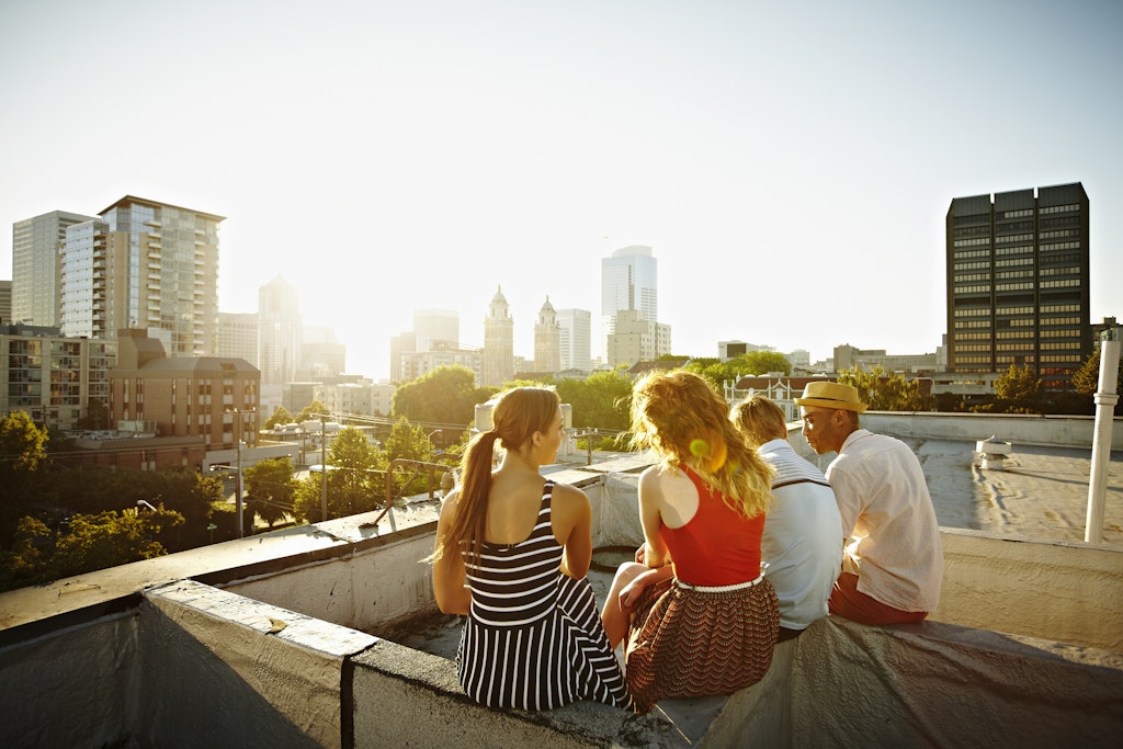Group of friends sitting on roof ledge at sunset looking out at cityscape rear view
153531489
Discovery, Relaxation, Simplicity, Support, Togetherness
Group of friends sitting on a rooftop in Seattle watching the sunset