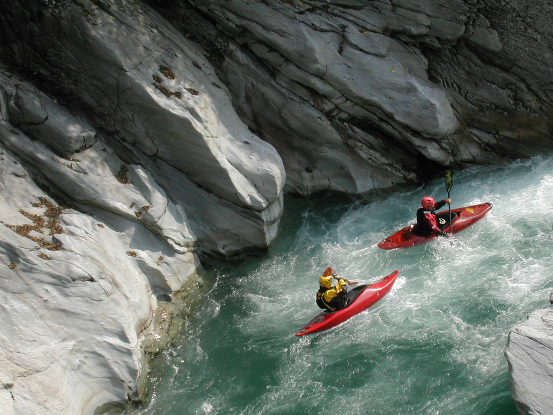 Two kayakers in rushing water in Valsesia, Piedmont, Italy
