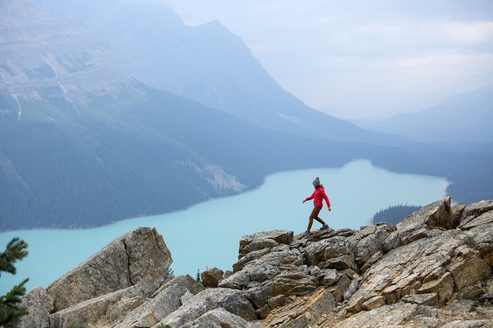 A woman hiking above a vibrant turquoise lake in Banff National Park.