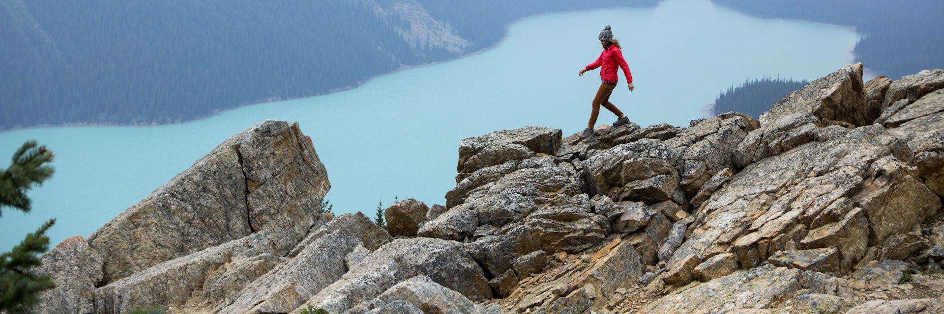 A woman hiking above a vibrant turquoise lake in Banff National Park.